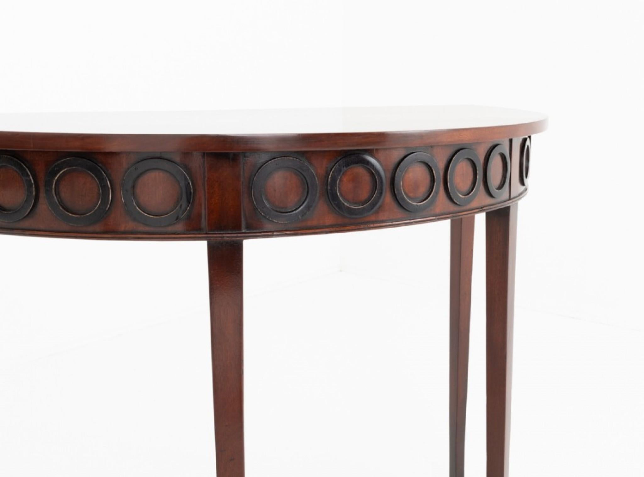 Pair of Georgian mahogany demi lune console tables.
Period Georgian antique
These elegant console tables stand upon tapered legs.
The frieze on each of the tables features a series of ebonised rings.
Presented in good condition.