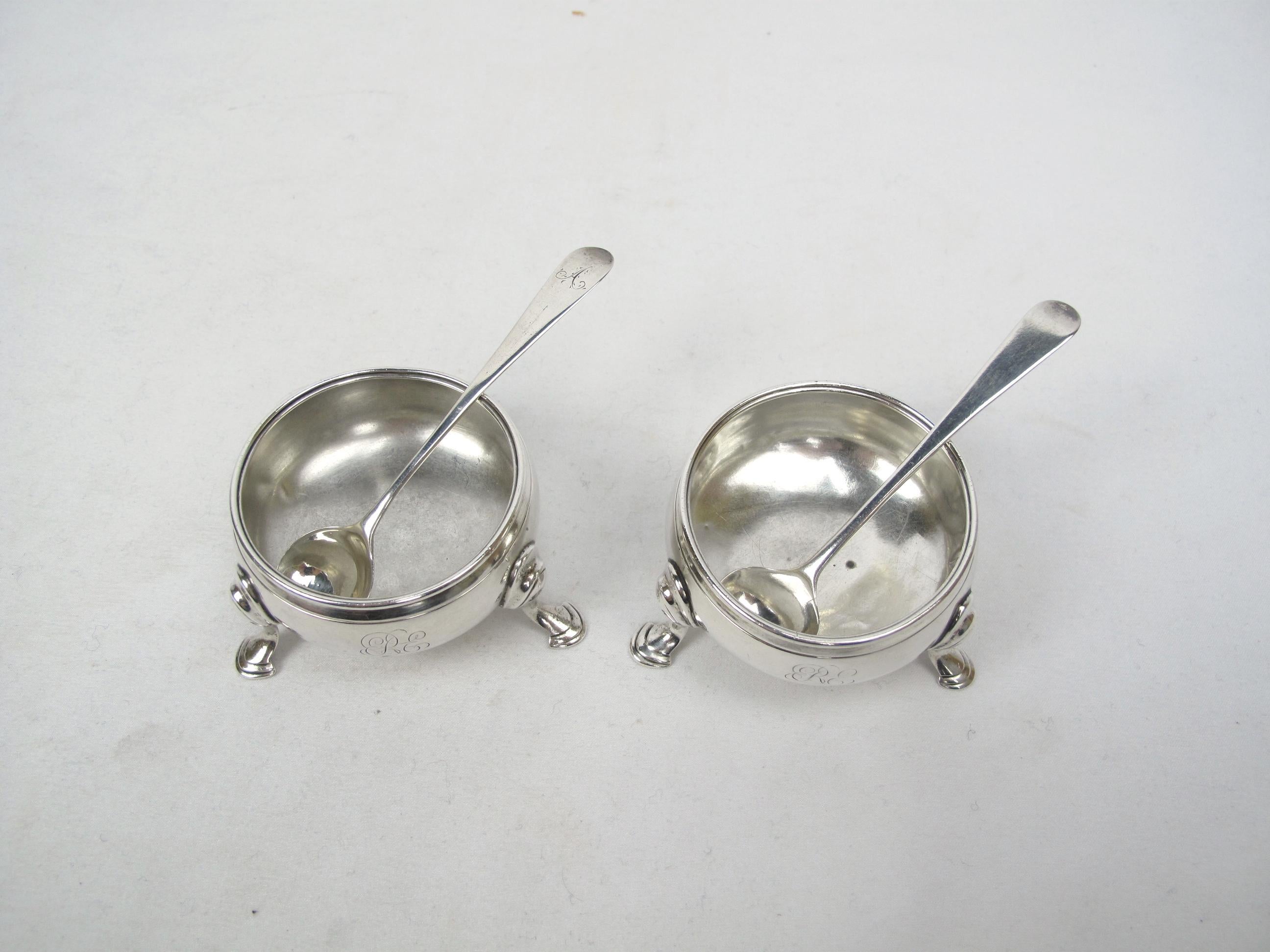 A matched pair of Georgian period sterling silver salt cellars by the father & son master silversmith team of David and Robert Hennell. 
These are 1 3/8 inches by 2 3/4 inches with bowls of 2 3/8 inches in diameter. They have plain beaded edges and