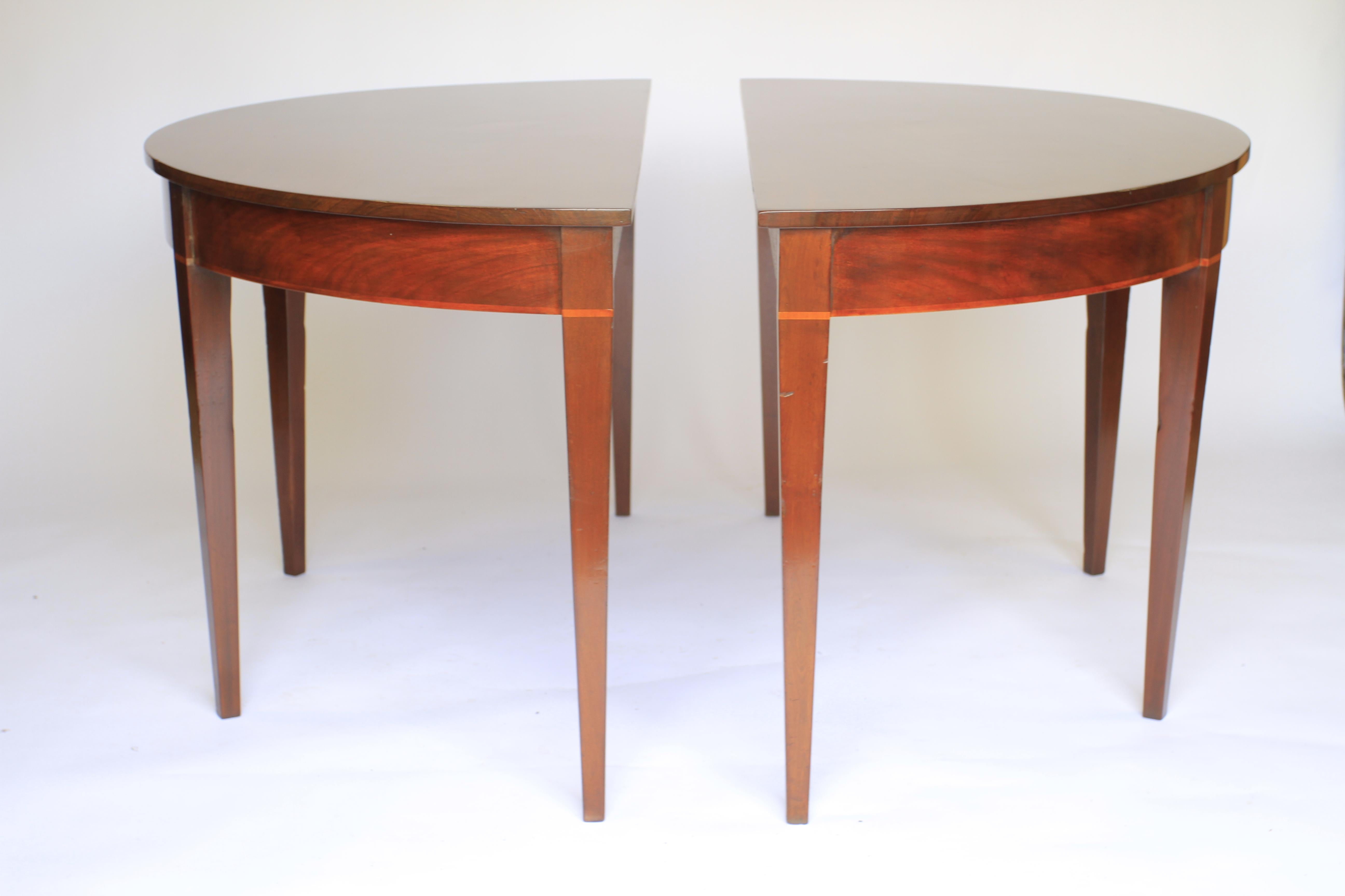 Pair Georgian Mahogany  Demi Lune shaped Console tables
Solid Mahogany tops 
Apron with Figured Mahogany veneer with boxwood line inlay
4 Mahogany Square tapering legs
Very good quality tables
Very good quality timber
Recently polished