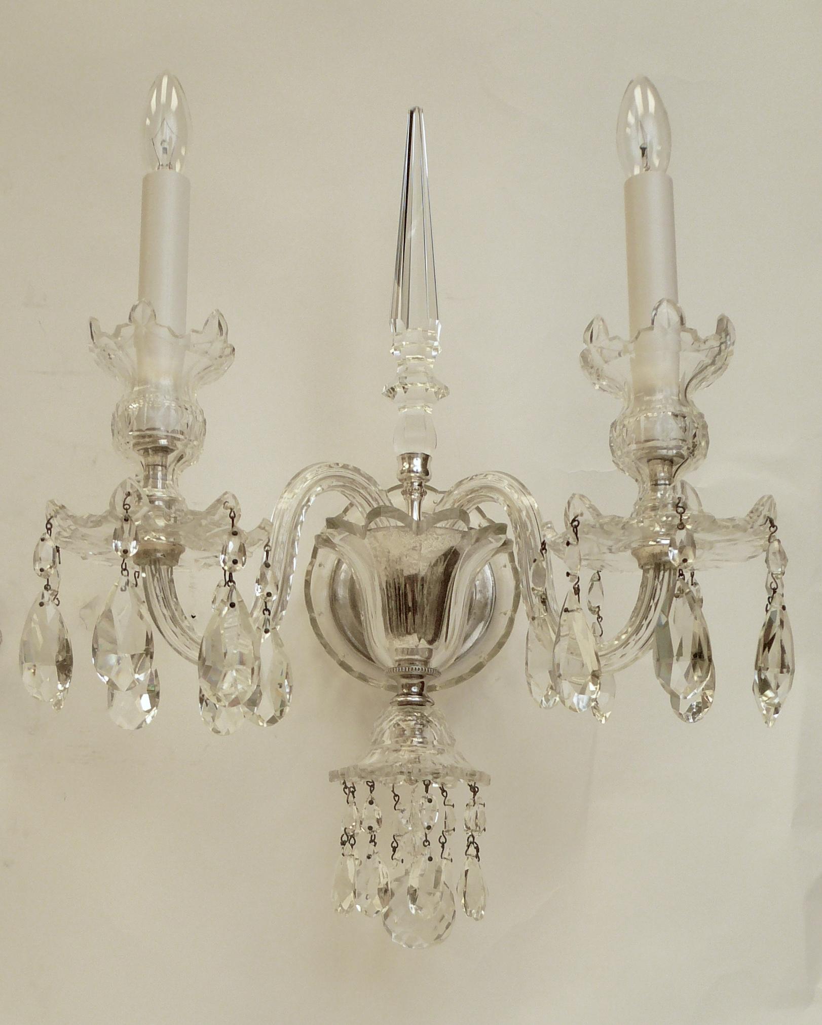 This pair of George III style crystal and silvered bronze sconces are of the finest quality, and feature cut crystal obelisks.