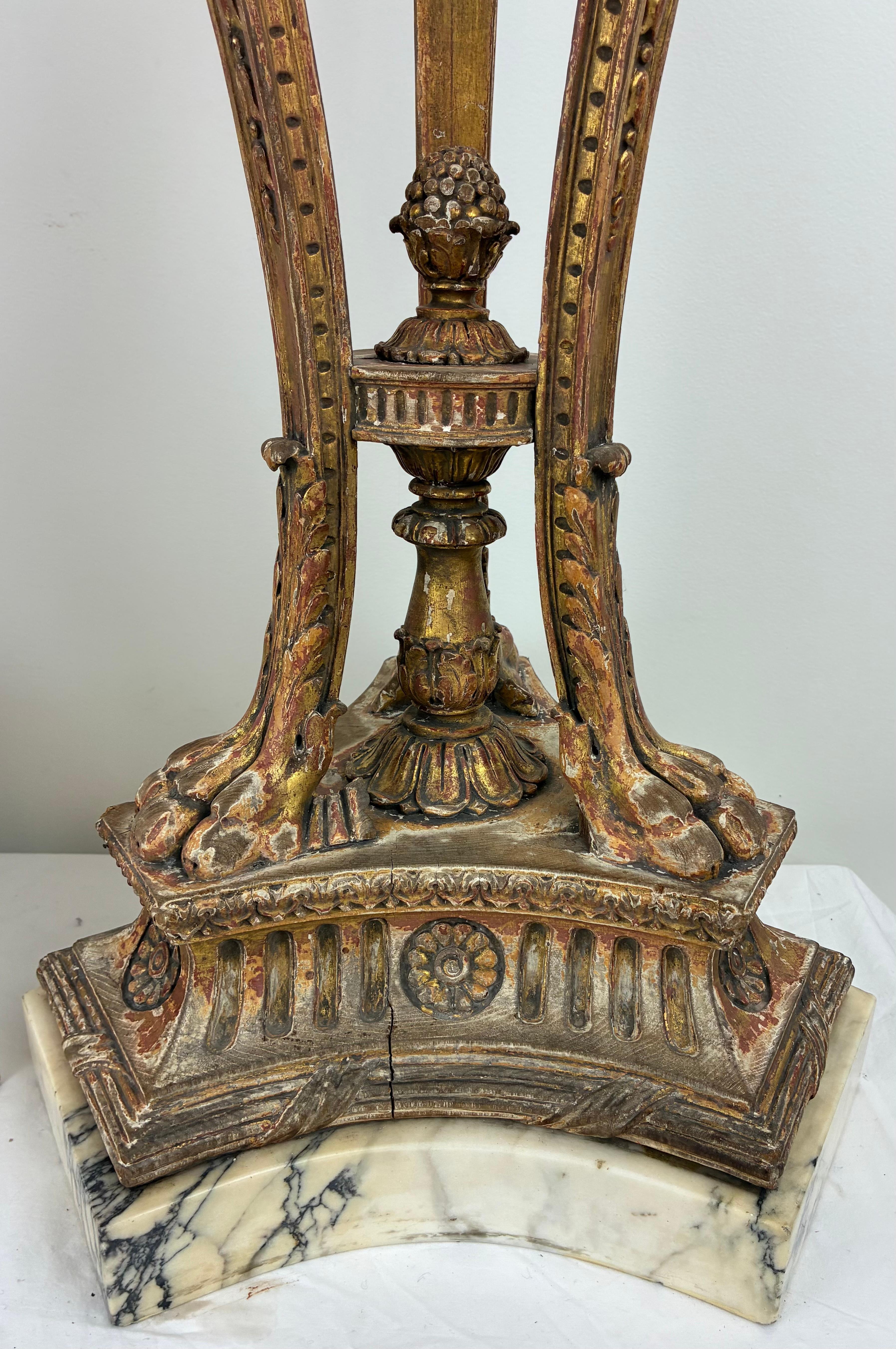 L'incredibile coppia di supporti in legno intagliato e dorato è in stile George III e presenta motivi neoclassici in stile Robert Adams. La base a forma di treppiede ha piedi a zampa intagliati che sostengono gambe a volute ornate da foglie