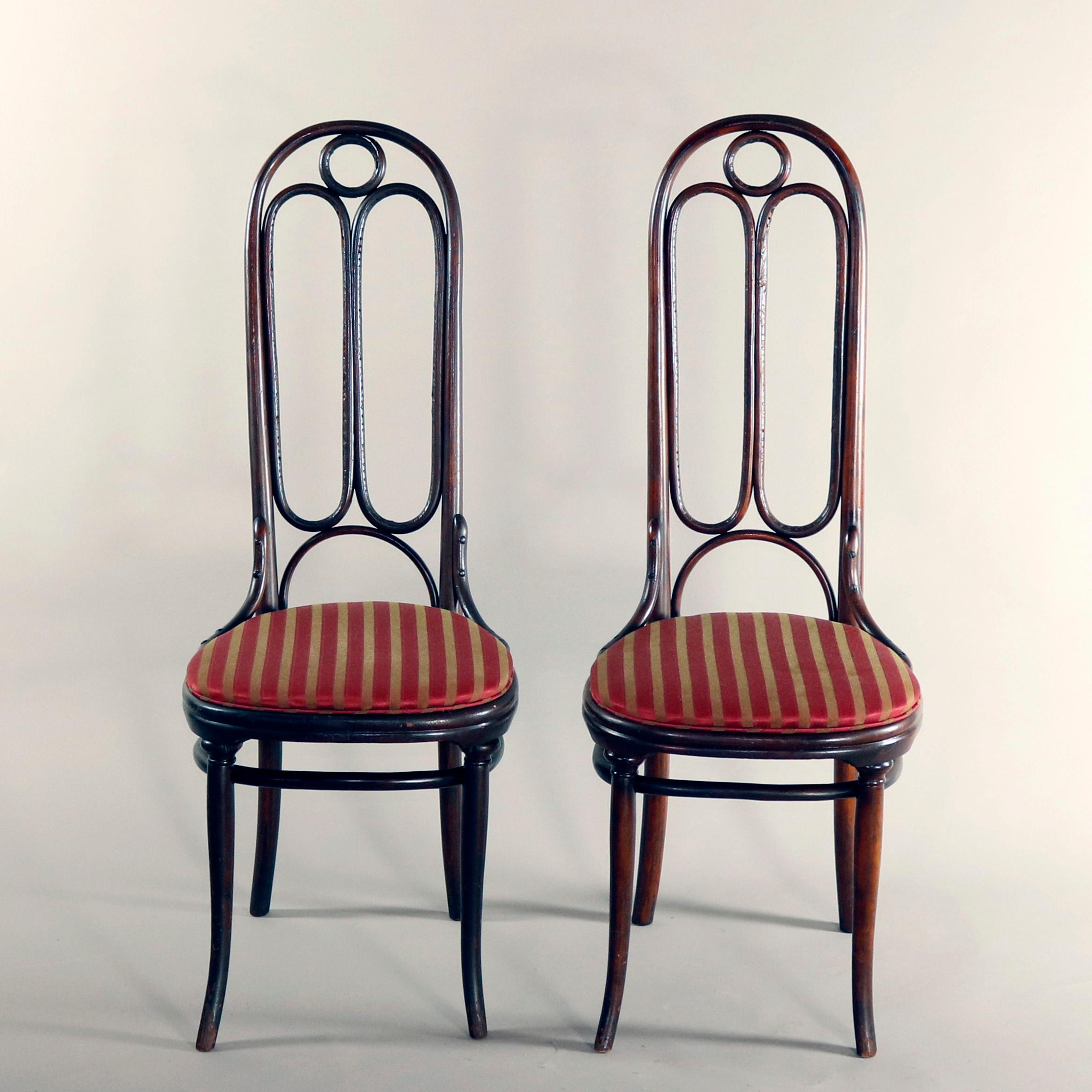 A pair of German antique chairs by Michael Thonet offer tall back bentwood frame chairs offer tall backs and upholstered seats, signed Thonet, circa 1900

Measures: 46.25