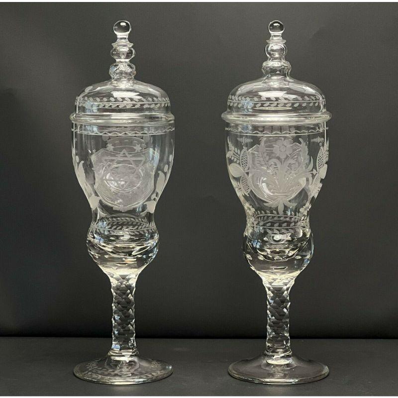 Pair German cut & engraved glass covered pokals, 1st half 20th century.

Clear glass with diamond pattern cut stems and lids. Decorative armorial crests prominently featuring an eagle engraved to each, both with floral decoration.

Additional