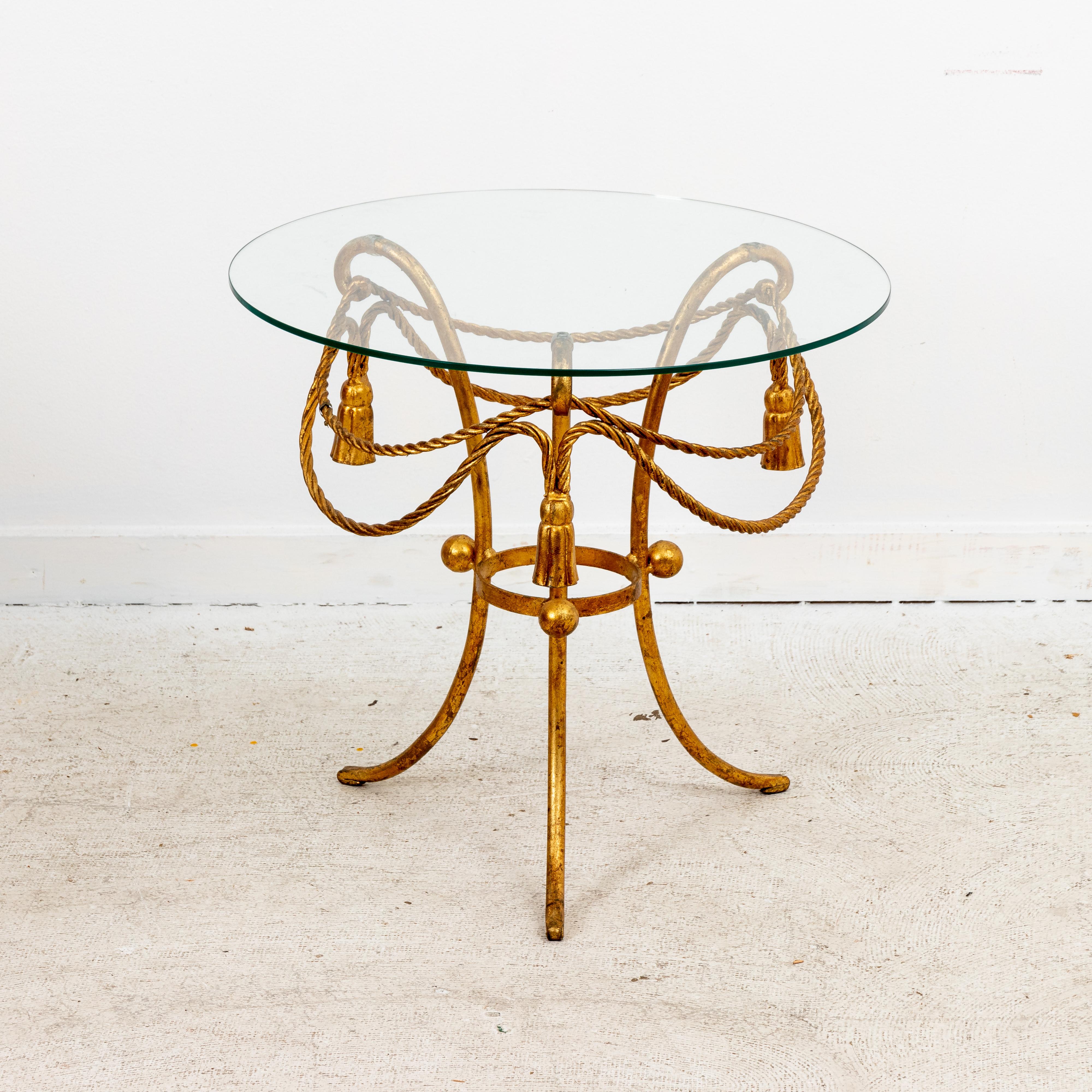 Pair gilded rope and tassel side tables with round glass tops. Made in Italy. Bases in good condition, some scratches to glass tops from age and use.