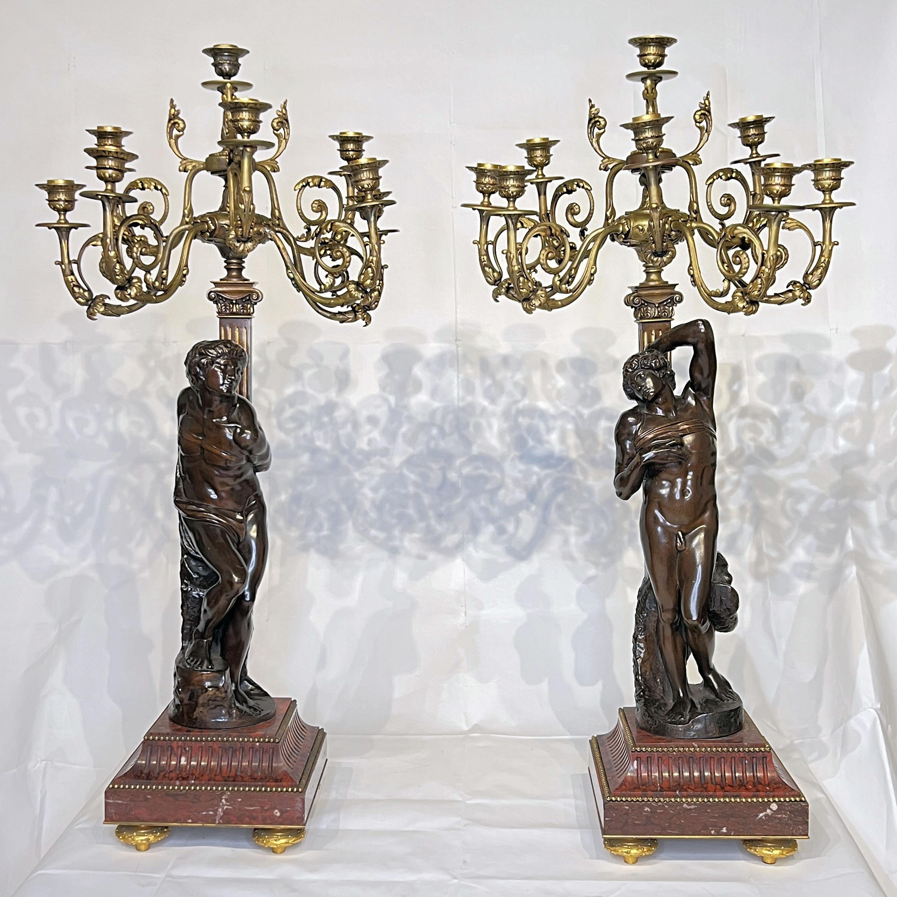 Pair of French 19th century patinated bronze candelabra of the finest quality by Barbedienne of Paris, mounted on rouge marble bases, after the original slave sculptures by Michelangelo.