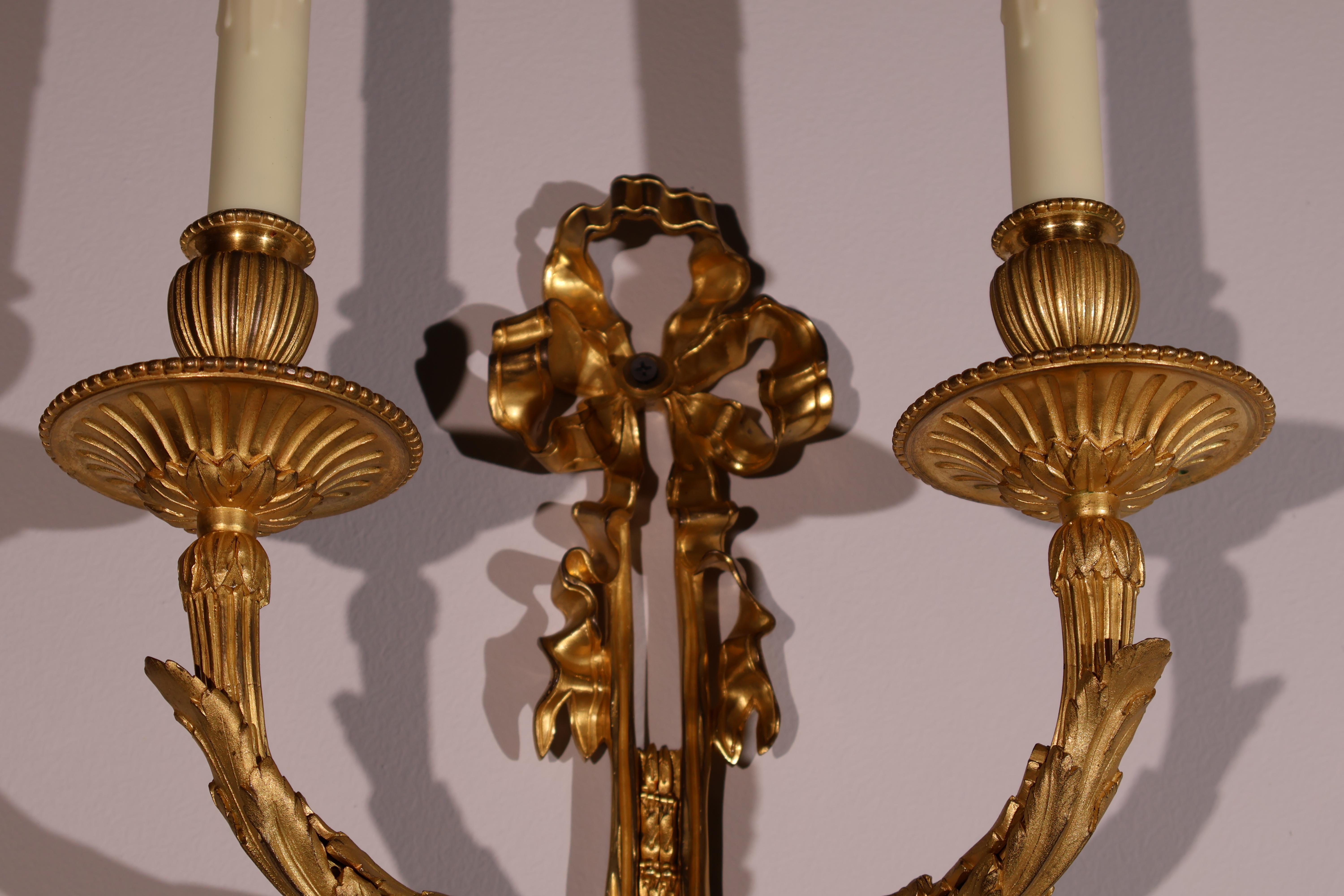 Très belle paire d'appliques murales en bronze doré de style Louis XVI. Ciselure exquise et détails minutieux. France, vers 1900. 2 lampes chacune. 
Dimensions : Hauteur 22 1/2