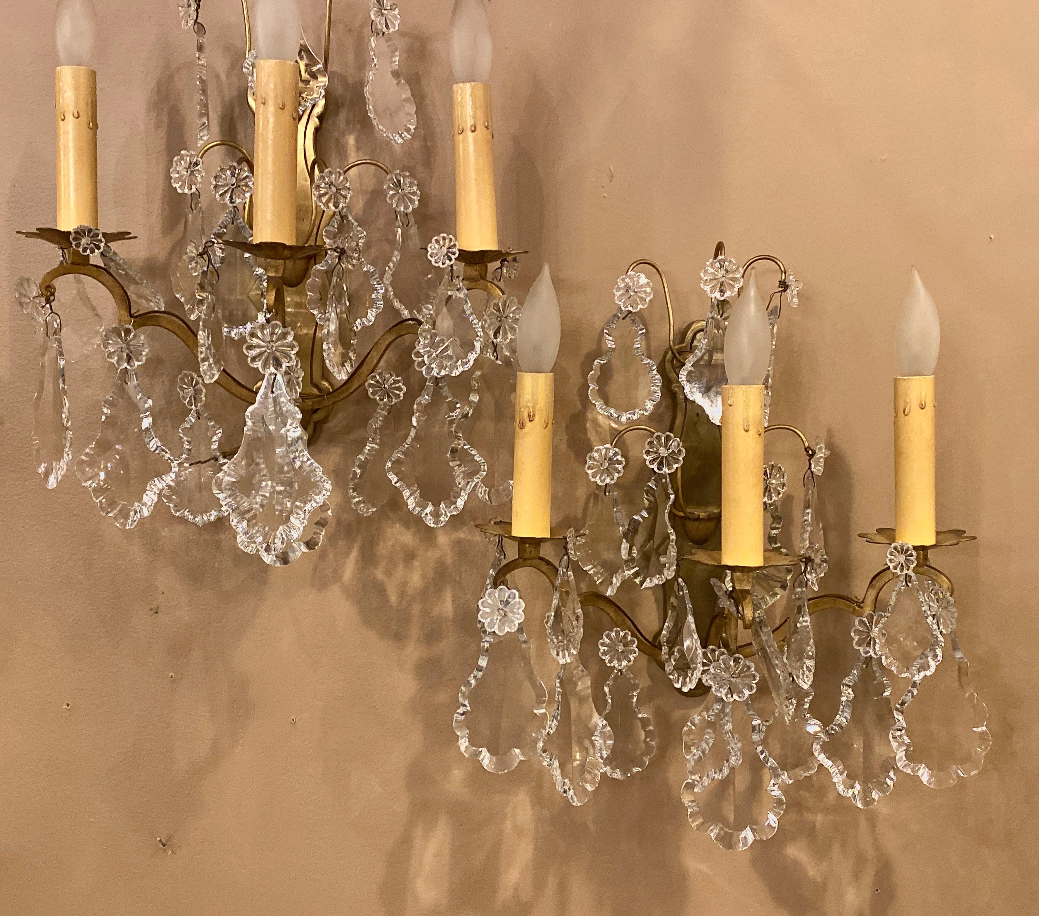 Pair gilt bronze and crystal three-light wall sconces French early 20th century. Each with a solid bronze back plate and large impressive nicely cut crystals. These can be shipped via UPS> 
1SX.