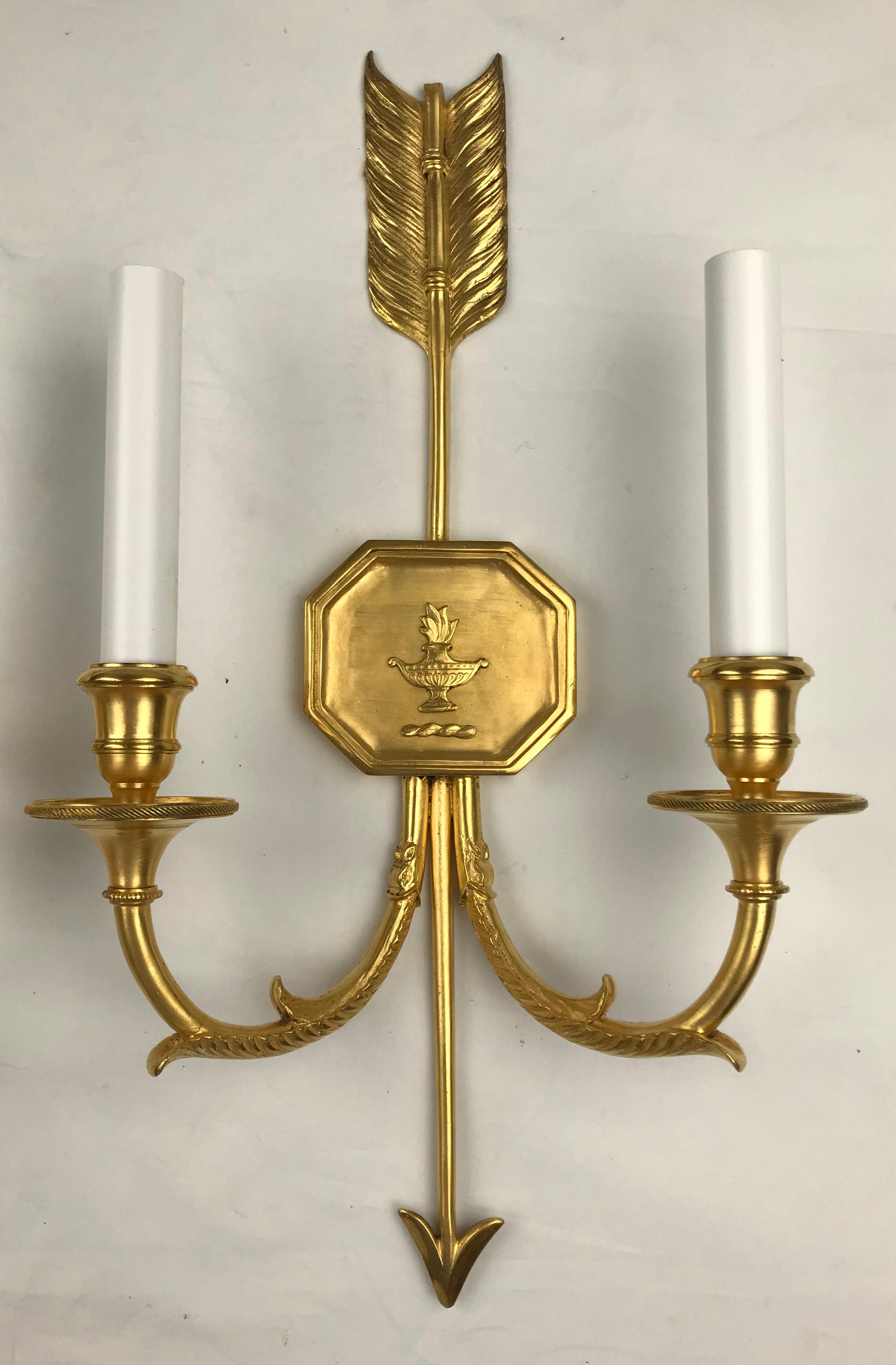 Questa bella coppia di appliques firmate è opera della famosa ditta Edward F. Caldwell. I bracci gemelli con motivi classici partono da piastre posteriori a forma di freccia. Queste applique sono state ricablate di recente e sono pronte all'uso.