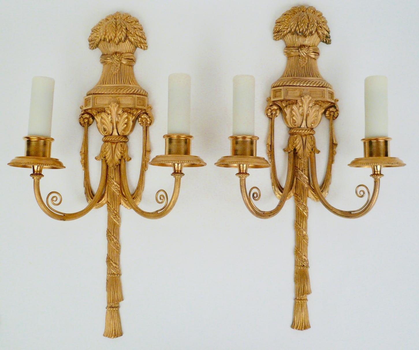 This handsome pair of gilt bronze sconces feature Classical motifs including acanthus leaves, swags and tassels. They are in excellent condition, retaining their original gilding, and are signed Caldwell.