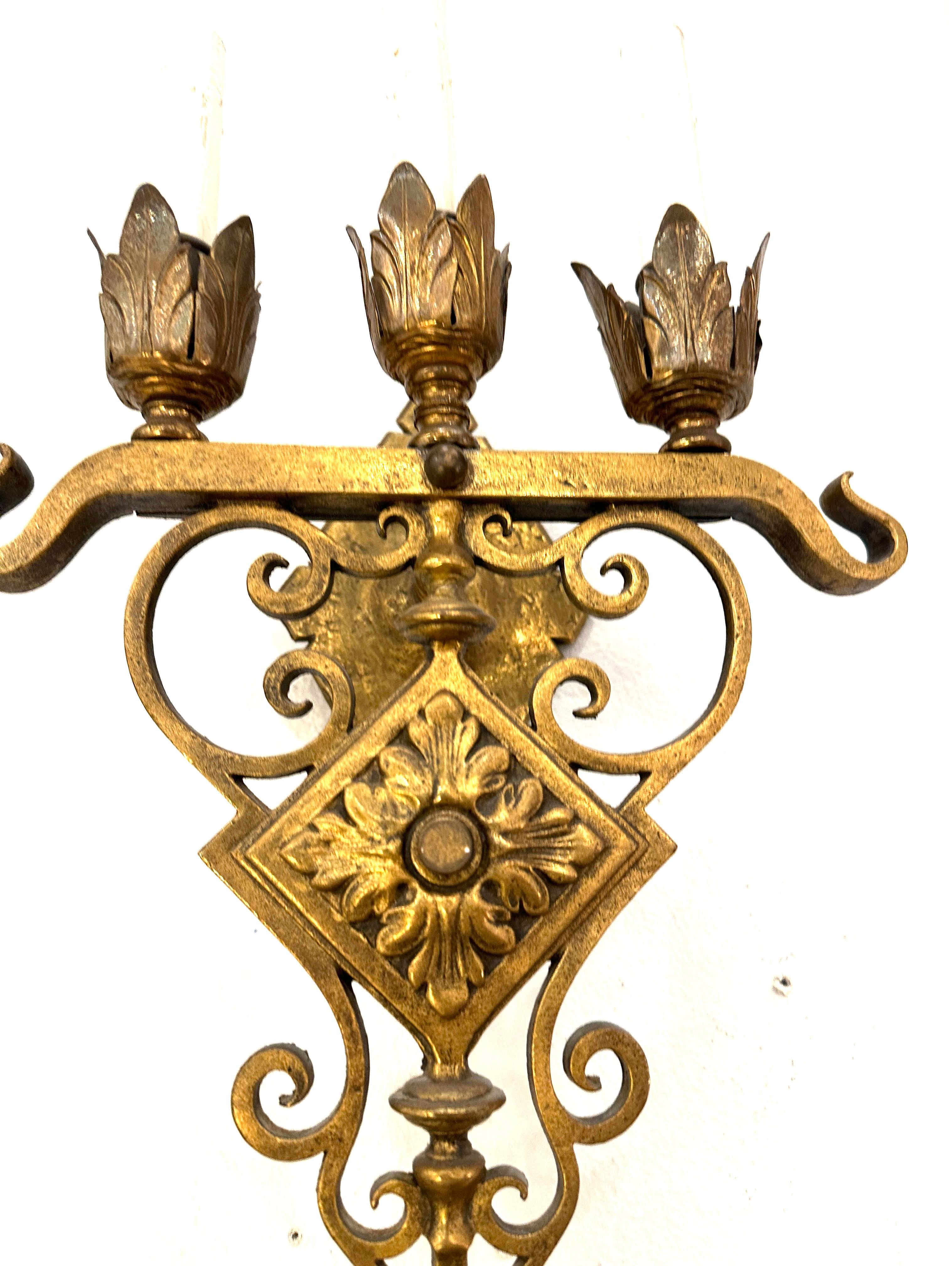 1930s Gilt Bronze wall sconces.  Each sconce has three candle lights,  Electrified, in charming flower style lights with shield shape support.