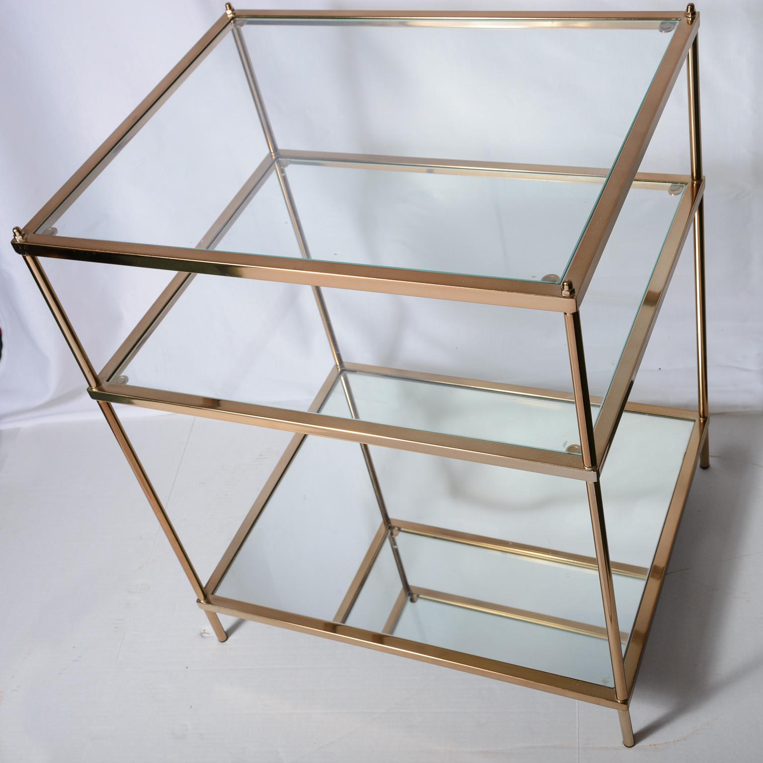 Pareja de mesas auxiliares de tres niveles de metal dorado y cristal al estilo de la Maison Jansen Hecho a mano en venta