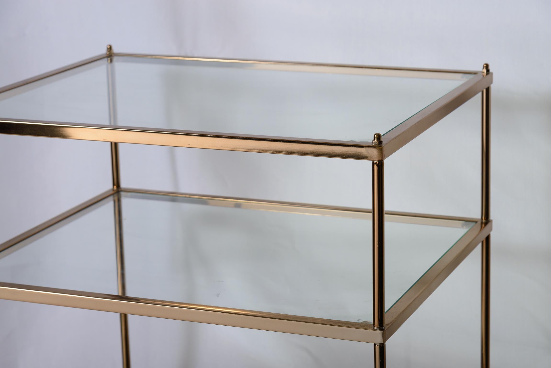 Pareja de mesas auxiliares de tres niveles de metal dorado y cristal al estilo de la Maison Jansen Metal en venta