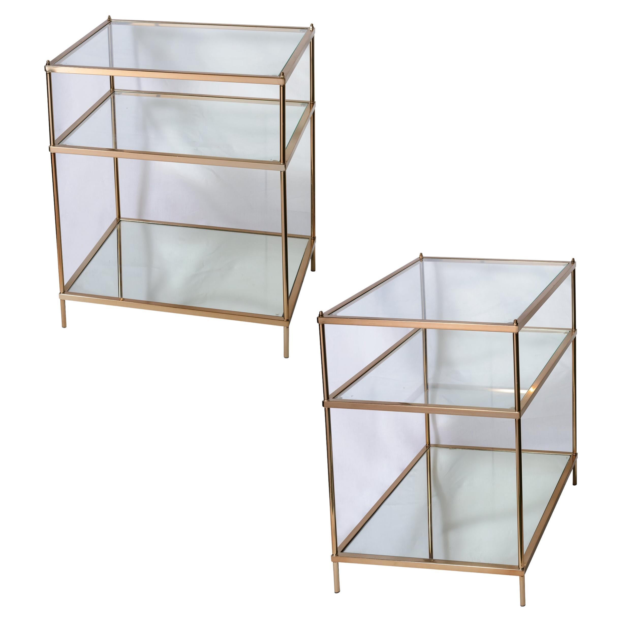 Pareja de mesas auxiliares de tres niveles de metal dorado y cristal al estilo de la Maison Jansen en venta