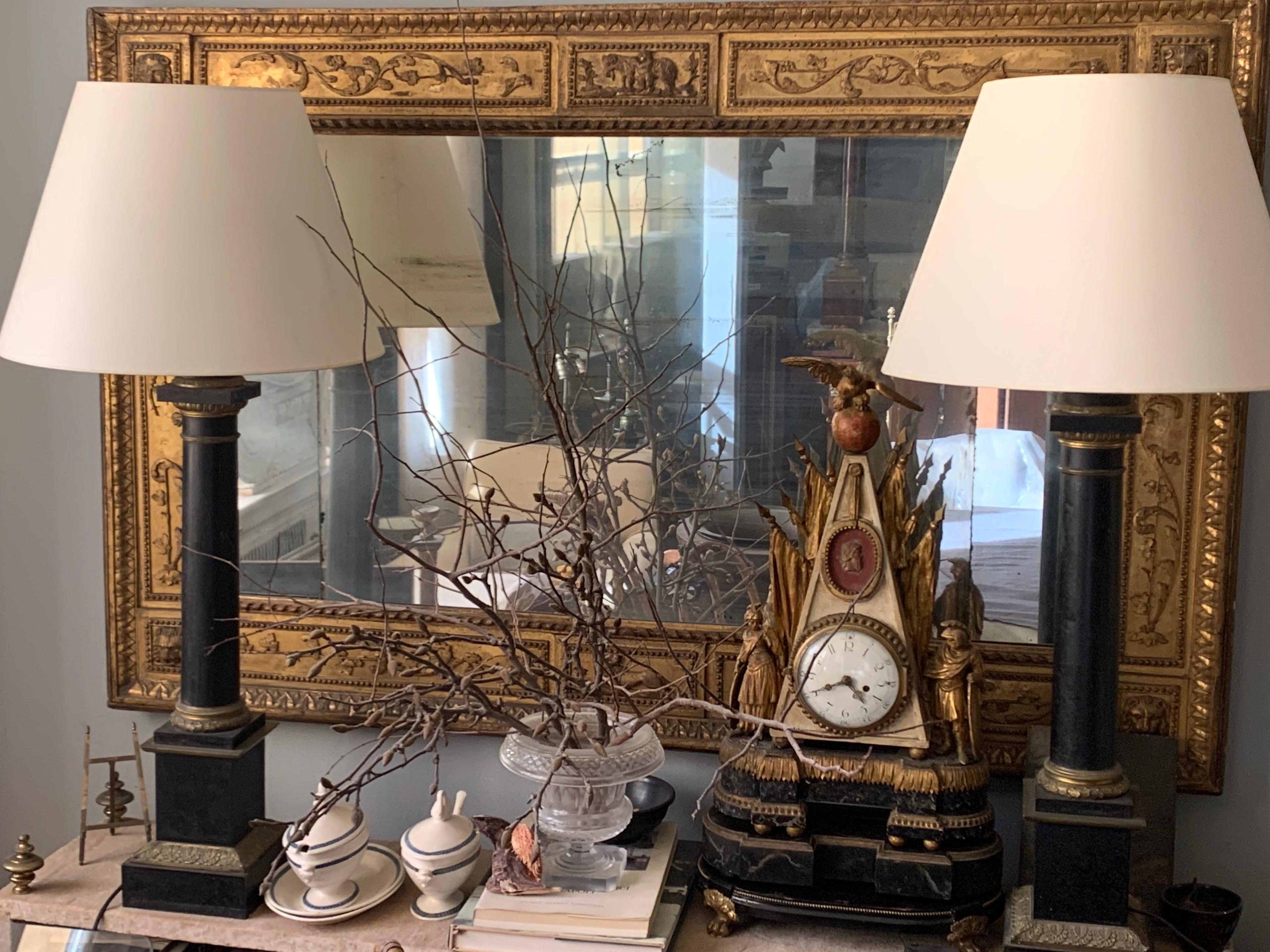 Pair gilt patinated metal column lamps. Pair of French neoclassical style large column oil lamps with egg and dart, laurel and acanthus details, with white paper shades. Stamped. Newly electrified with black silk cords. France, Mid-19th