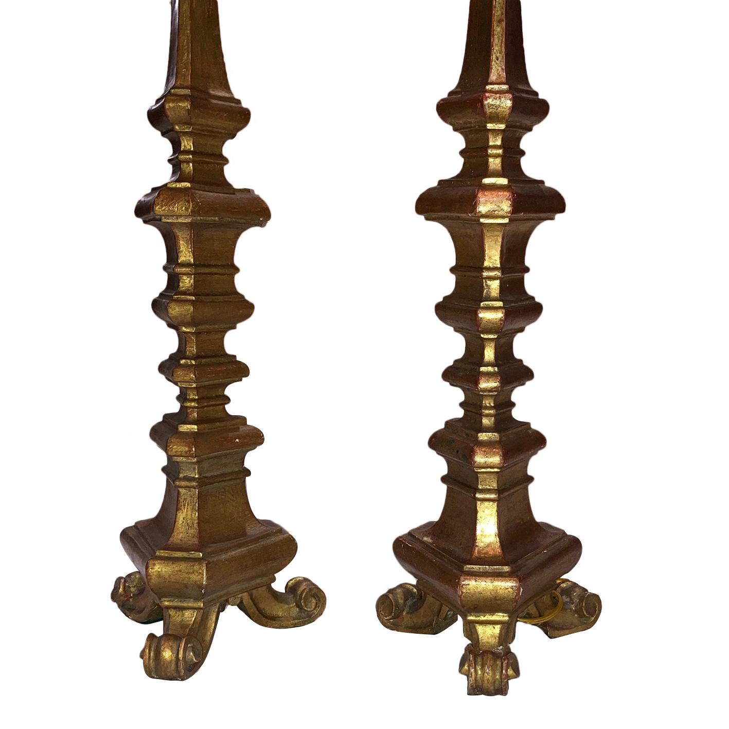 A pair of circa 1950s Italian carved and giltwood candlestick table lamps with original patina.

Measurements:
Height of body 23.5