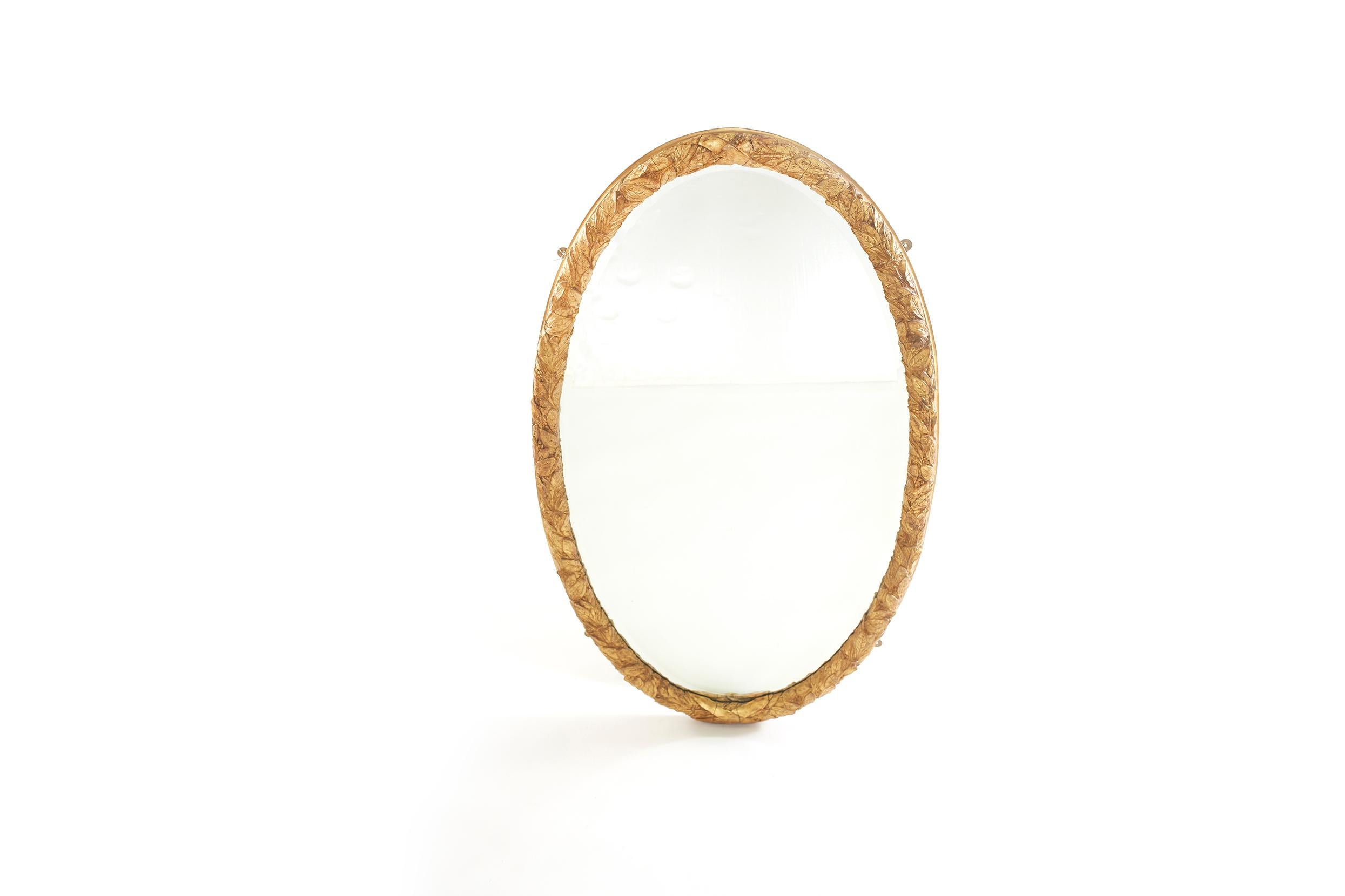 Precioso par de espejos de pared colgantes biselados con marco de madera dorada y forma ovalada con detalles de ramas de coronas muy talladas . El espejo está en buen estado. Pequeño desgaste / pérdida en el marco de madera dorada. Los marcos de