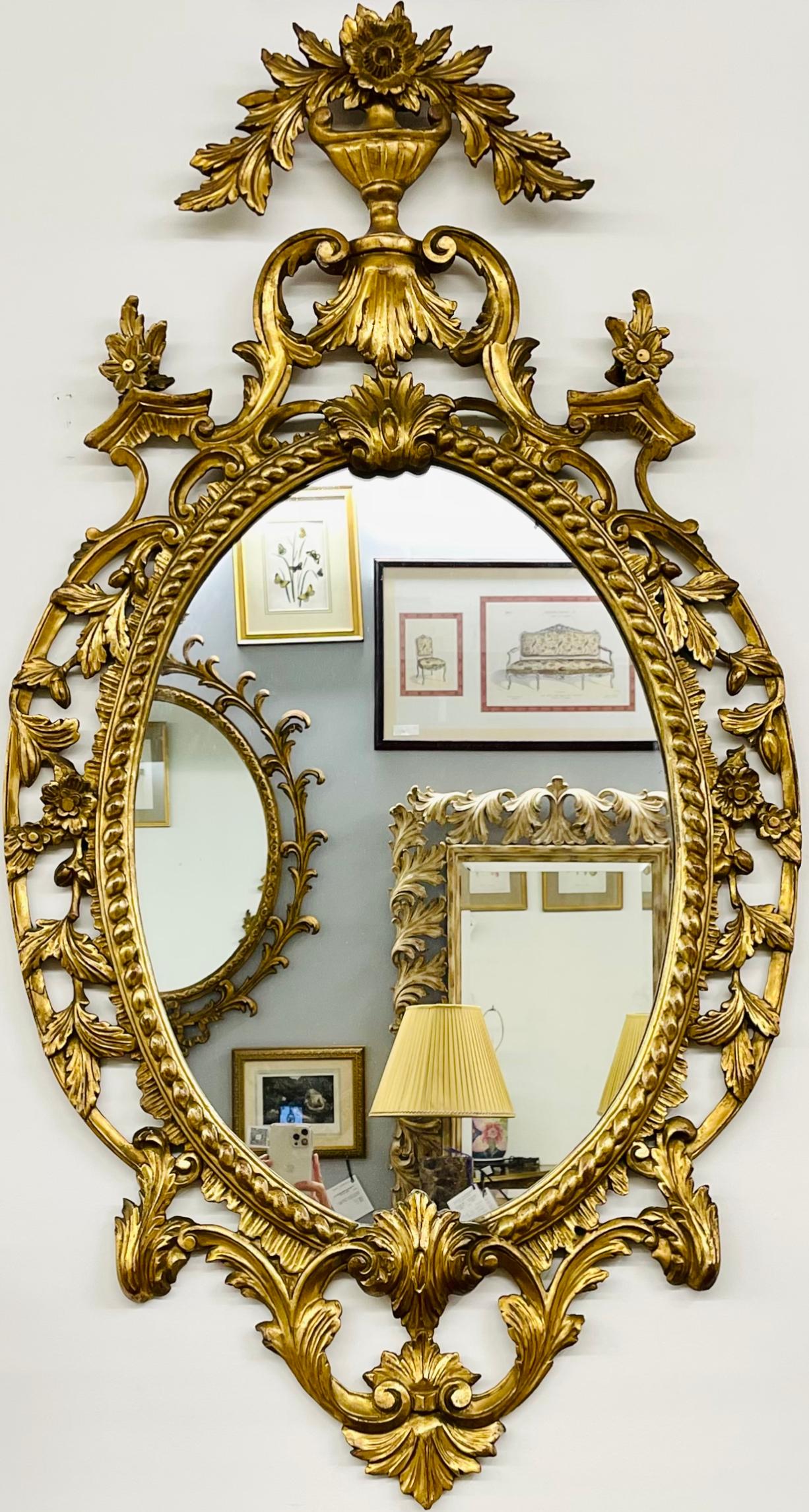 Paire de miroirs en bois doré. Chaque miroir mural ou console présente un miroir central transparent flanqué d'un cadre en bois sculpté et doré, orné de coquillages, de fleurs et d'un motif de volutes. Cette paire de miroirs muraux italiens finement