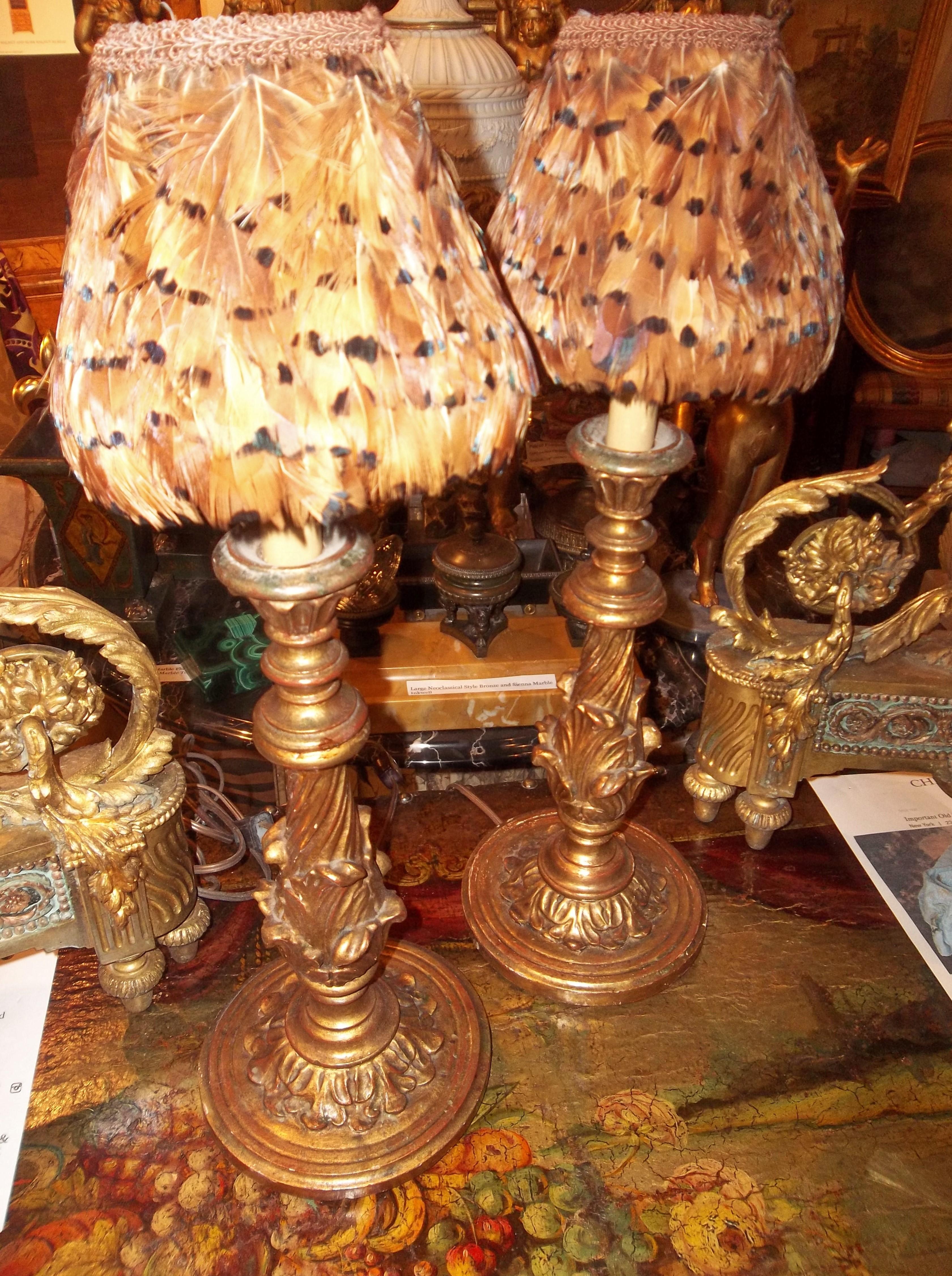 Pair of carved French or Italian  giltwood candlesticks  with feather shades. in the Louis XVI style . Newly wired for US wiring but as always all electrical should be checked . 

22 inches tall to top of shades , 6 inches diameter at base