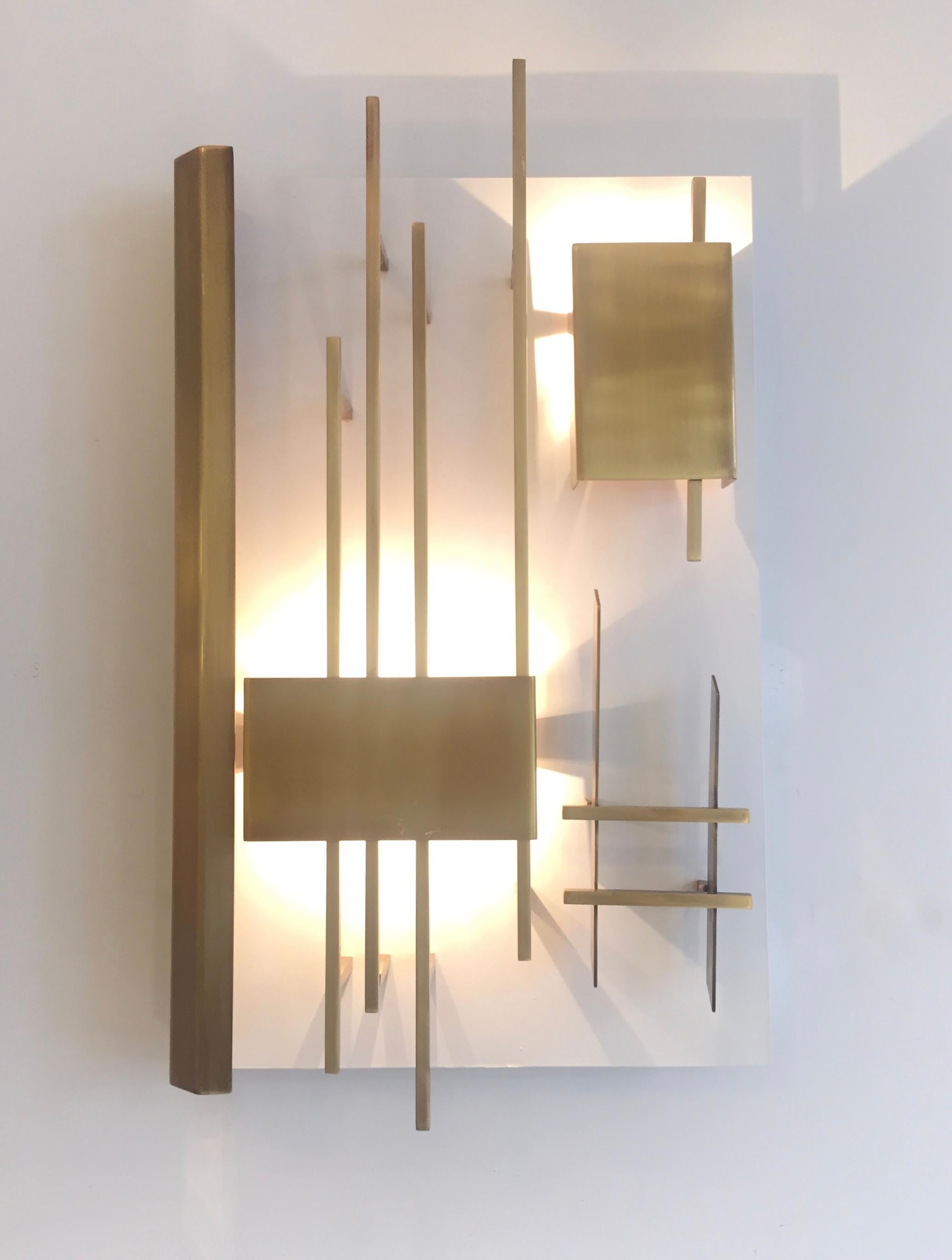 Pair of Gio Ponti vintage sconces, model 575, edited by Lumi in 1972.Brass and enameled brass architectural rods and geometric shapes fixed over a square plate of ivory lacquered metal.
Provenance:The sconces originate from the property of Madrid