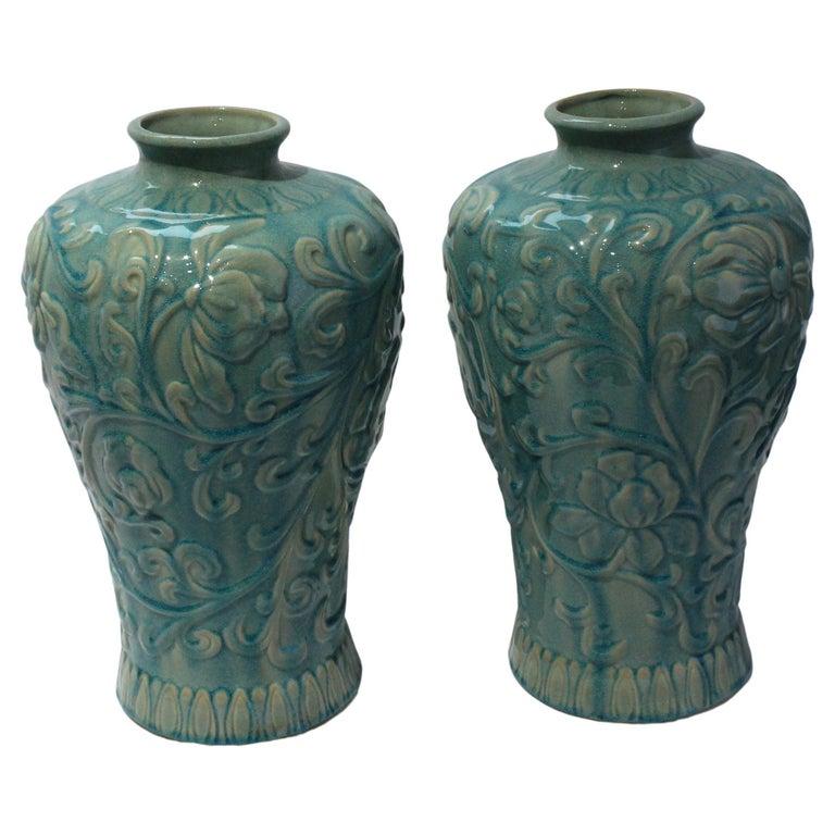 This stylish set of vases date to the 1980s-1990s and are decorated with unudulating floral motifs and finished with a flambe glaze of turquoise over a celedon green base color.