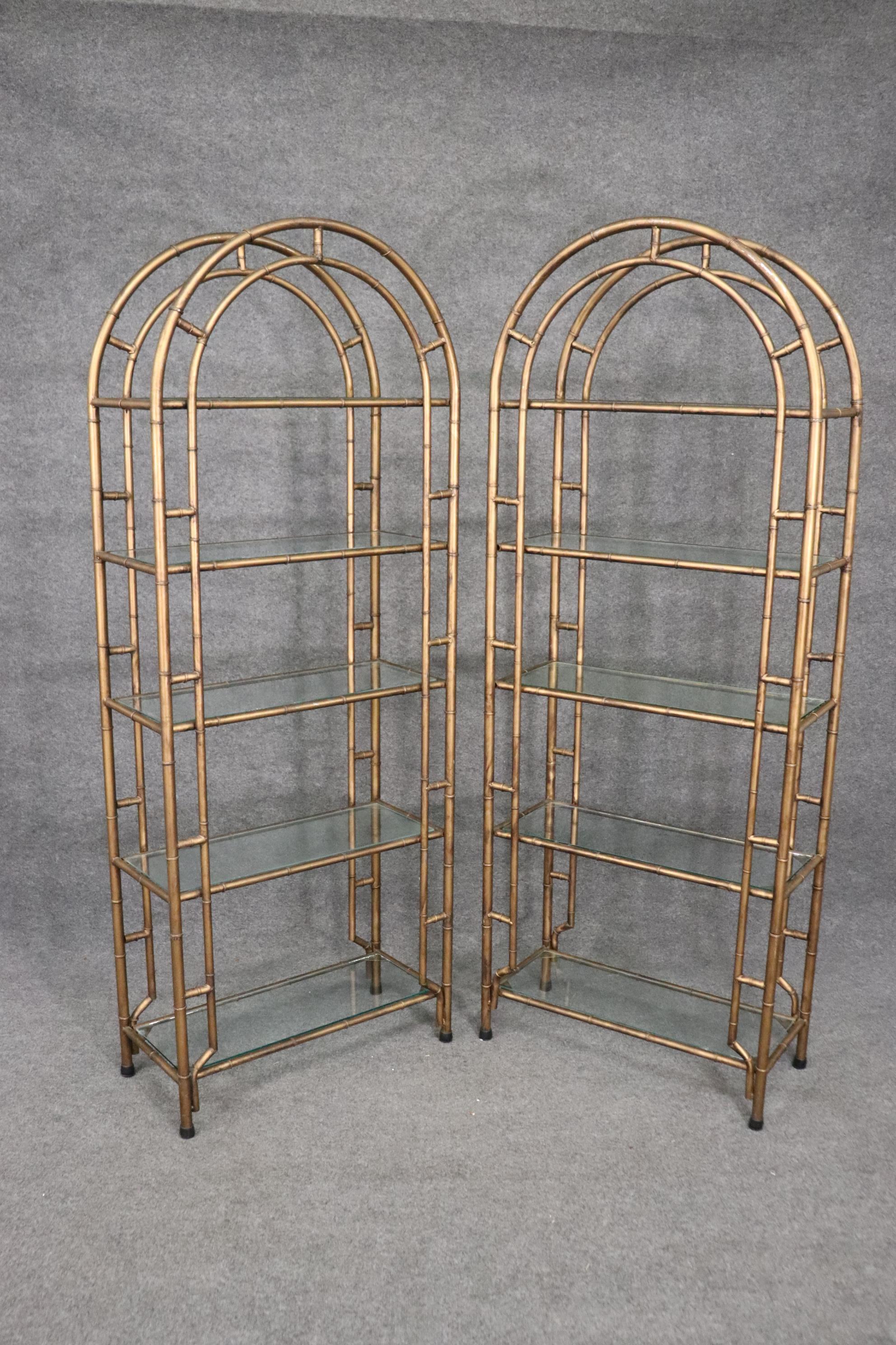 This is a beautiful and rare pair of gilded etageres in the Hollywood regency style. They are in good condition and measure 79 tall x 30 wide x 14 deep.