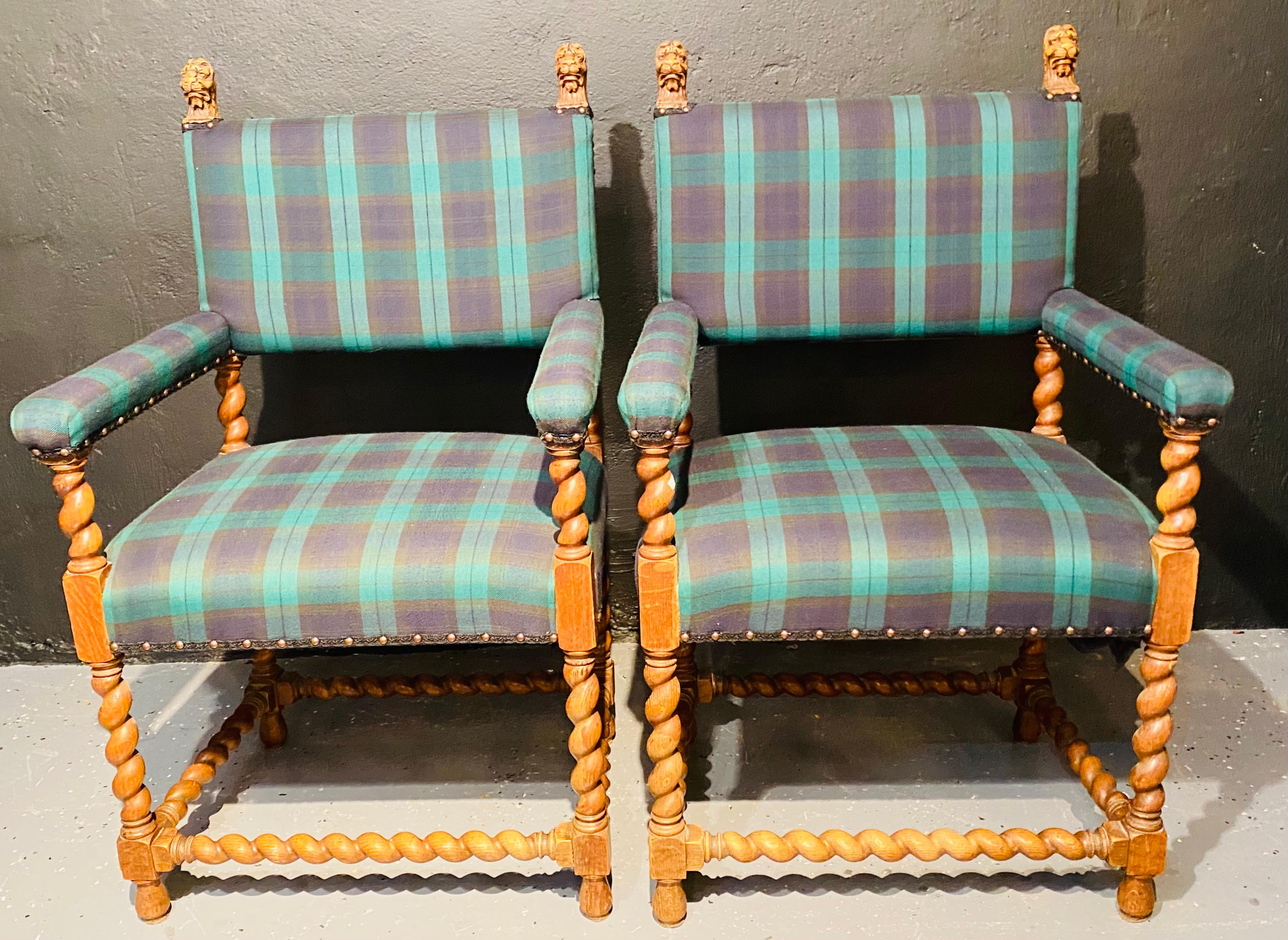 Pair of oak carved chairs in a Burberry style upholstery. Lion heads and spiral posts, outer barley twist stretchers. These finely carved and custom upholstered armchairs would look fine in any setting in the home or behind any work desk.
   