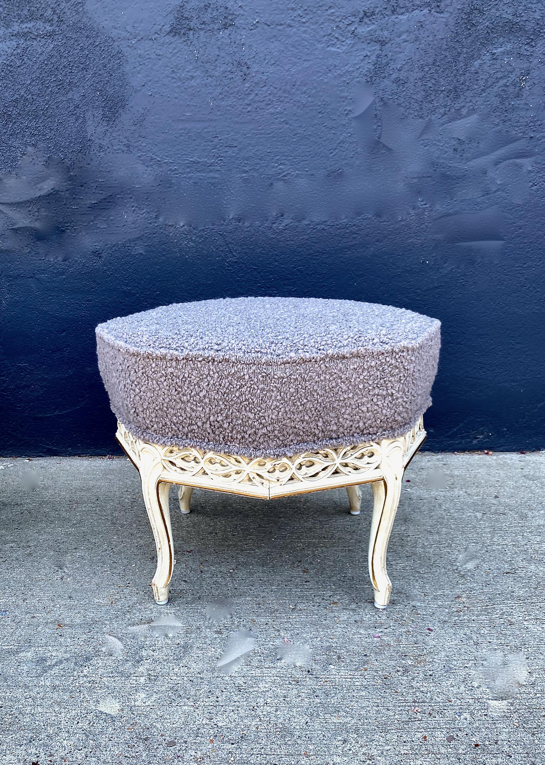 This is a unique pair of Gothic-Style stools that date to the early 20th century. The frames of the stools are well carved in an octagonal Gothic tracery design. The seats are newly upholstered in a rich gray Pierre Frey wool boucle. These stools