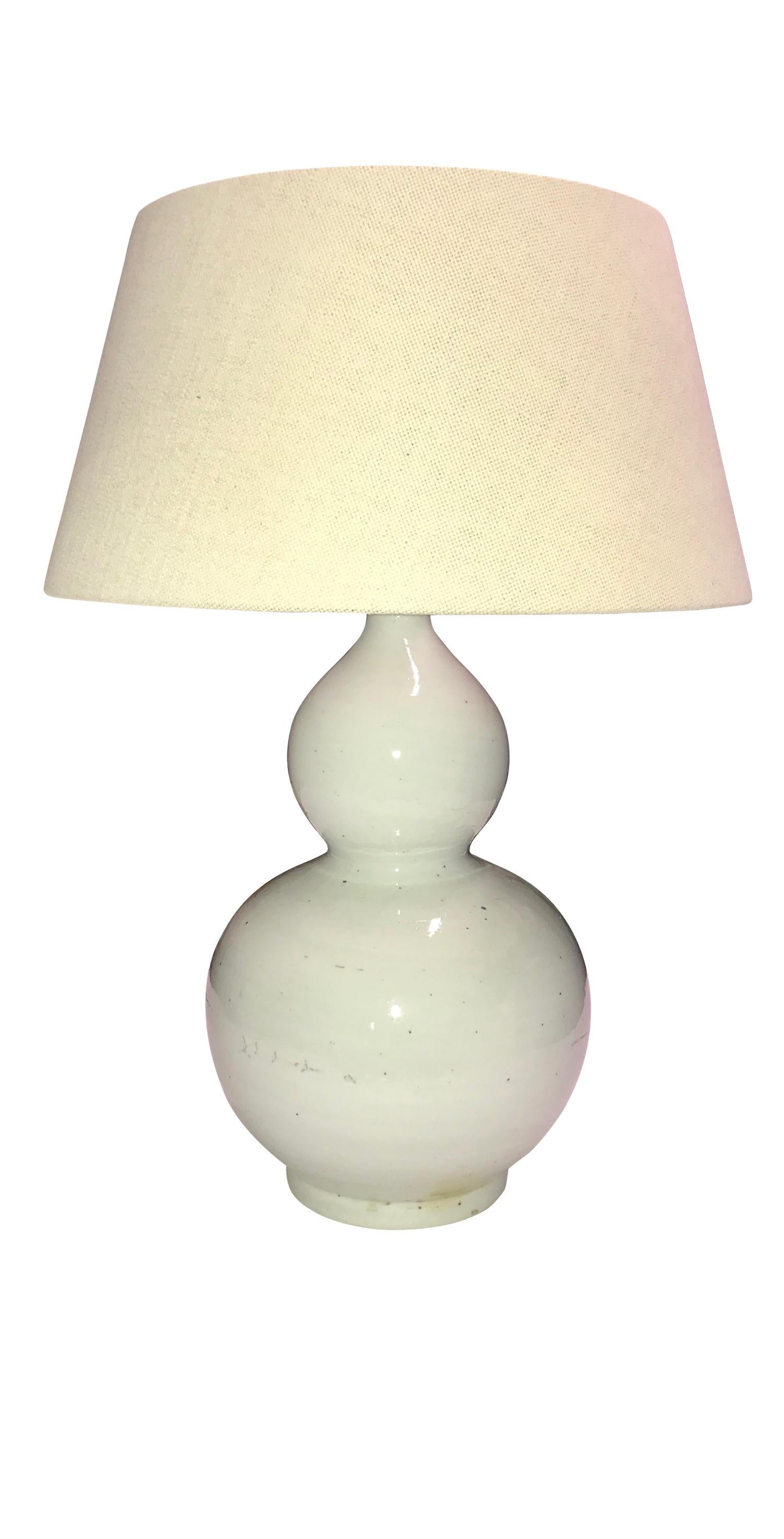 Contemporary pair of white glazed gourd shaped lamps
New Belgian linen shades
Measures: Overall height 24.5