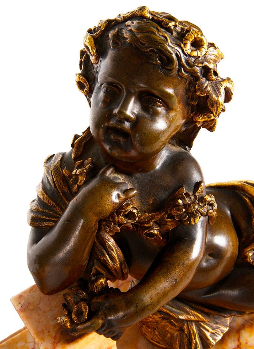 An enchanting pair of late 19th century patinated and gilded bronze reclining Bacchus influenced Putti, mounted on carved Sienna marble plinths.