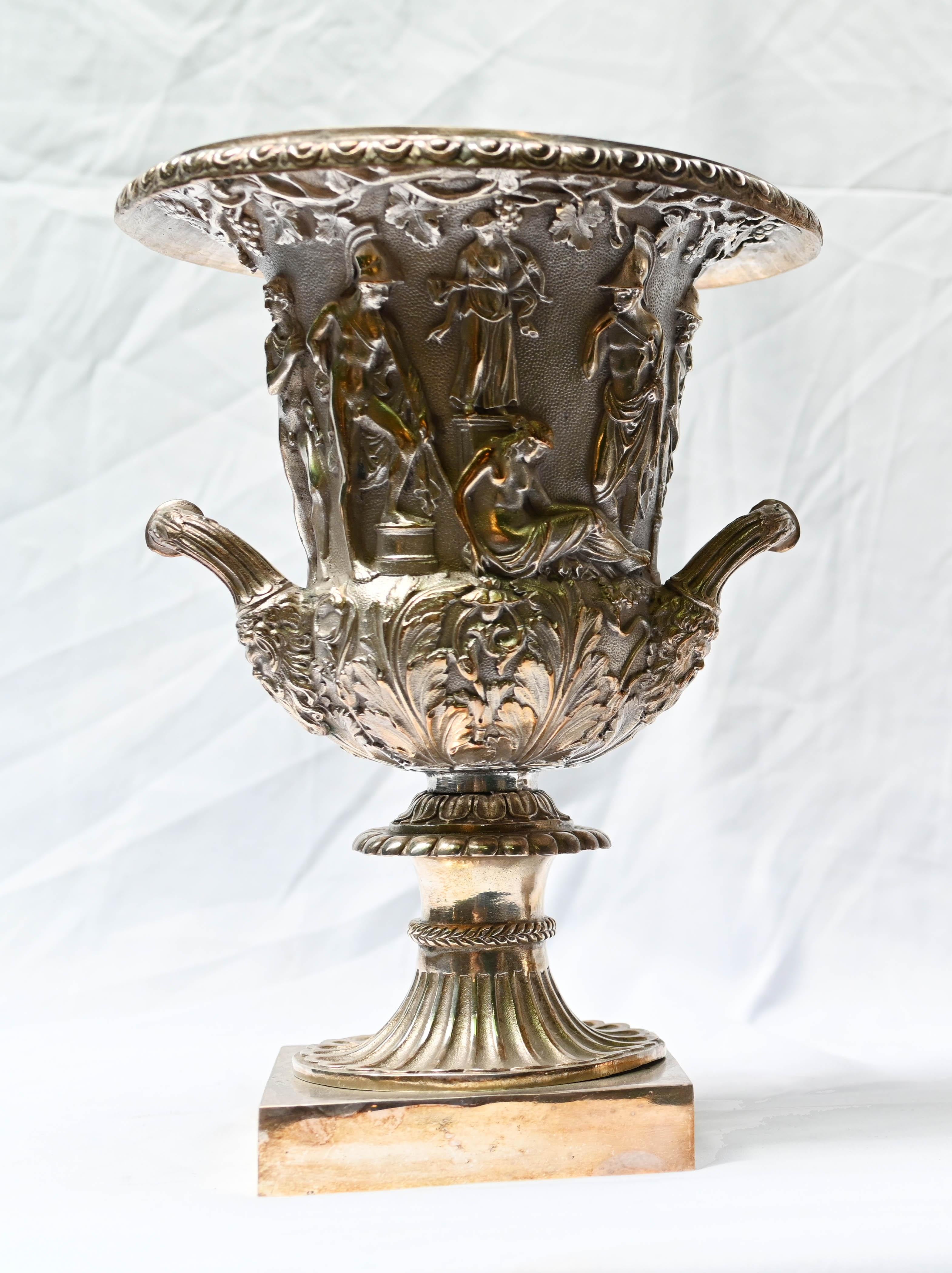 You are viewing a wonderful pair of silver plate urns of campana form after the famous Borghese vase
Heavy pair, very well cast and the details to the scenes in relief around the surface of the urns is incredible
The scene is one of a Bacchanalian
