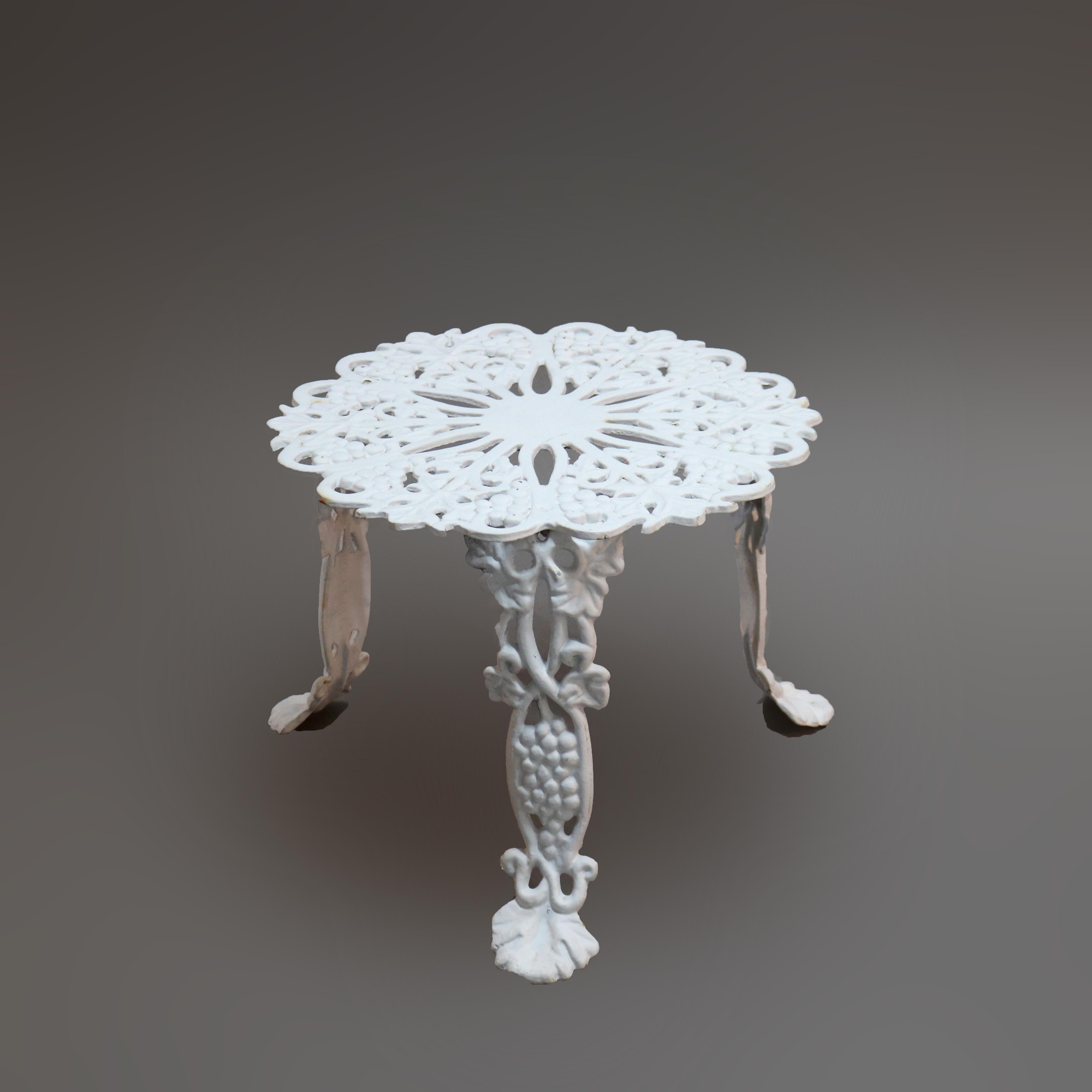 A garden set offers cast iron construction in grape and leaf pattern, painted white, set includes two arm chairs and center low table, c1940.

Measures - Chairs 26''H x 21.25''W x 21.25''D, 14'' seat height; Table 22.5''H x 22.5''W x 15.75''D.