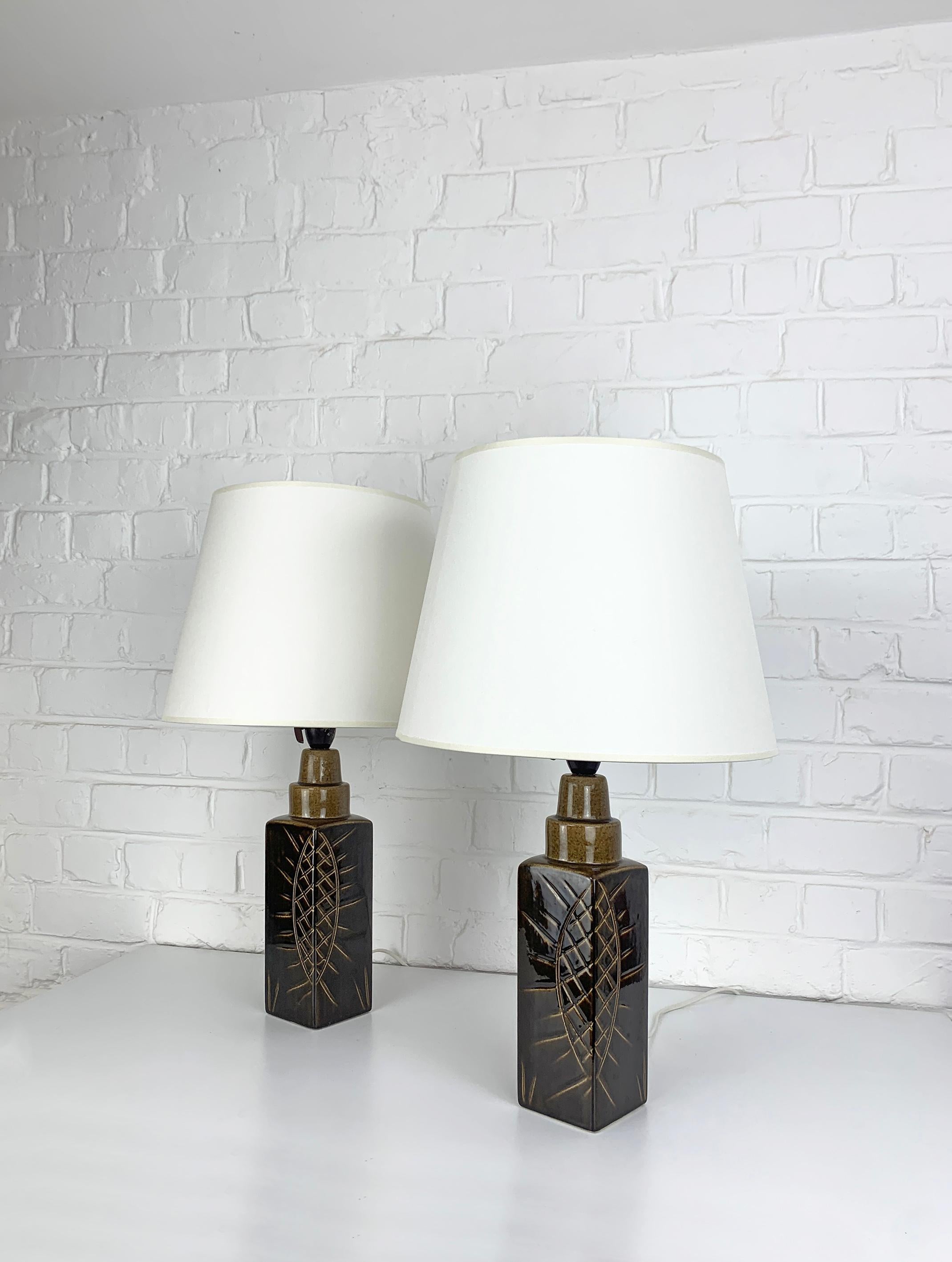 Pair of Danish Mid-Century stoneware table lamps of the 1960-70s.

Model 108, glazed in a brown colour with a graphic sun symbol.

Attributed to Søholm Stentøj (Soholm pottery) on the island of Bornholm, Denmark. 

Søholm Stentøj, which means