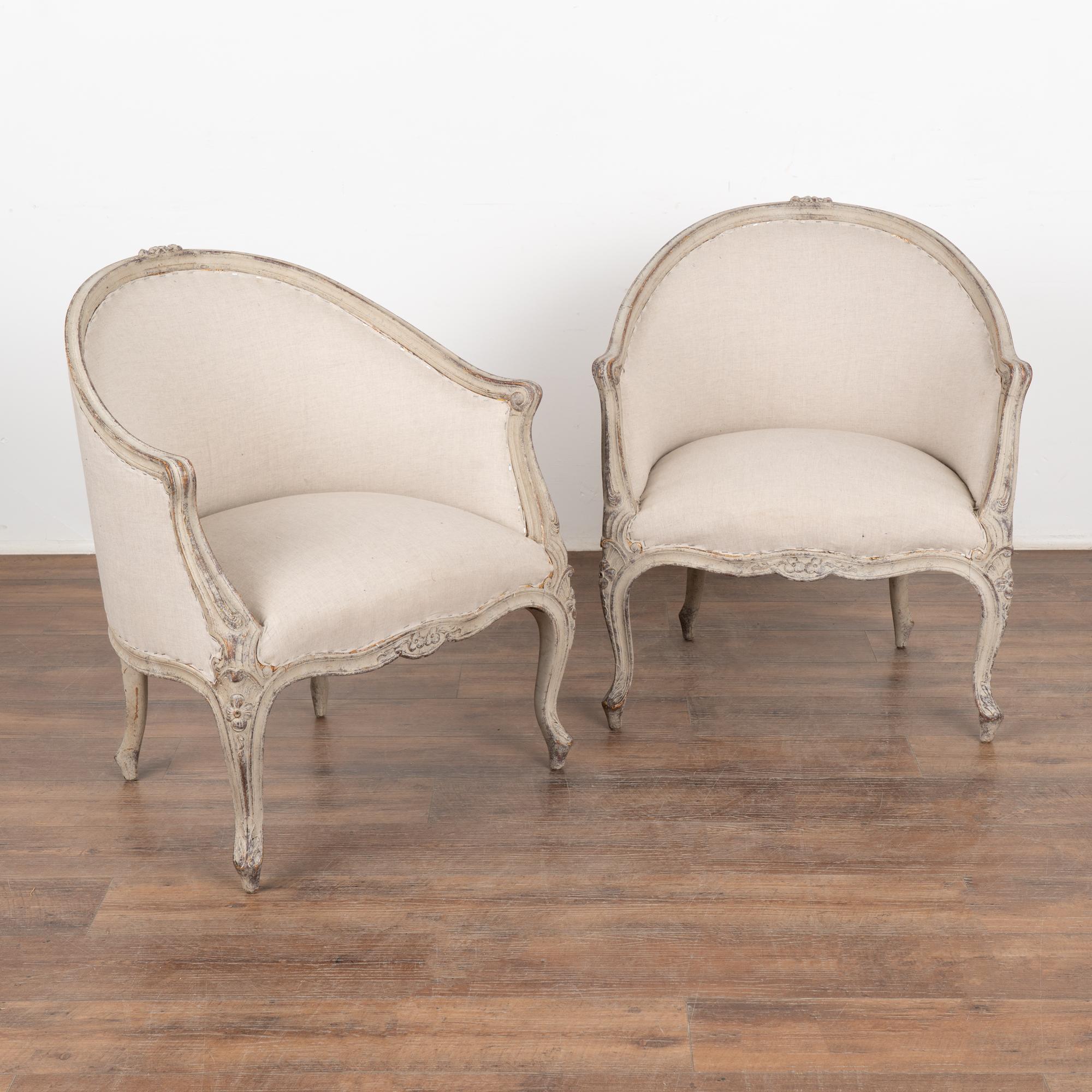 This pair of Swedish arm chairs have a gently curved barrel back and cabriolet legs adding to the graceful Gustavian appeal of each.
Delicate carving and curves are seen throughout the frame.
The newer professionally applied antique white/soft gray