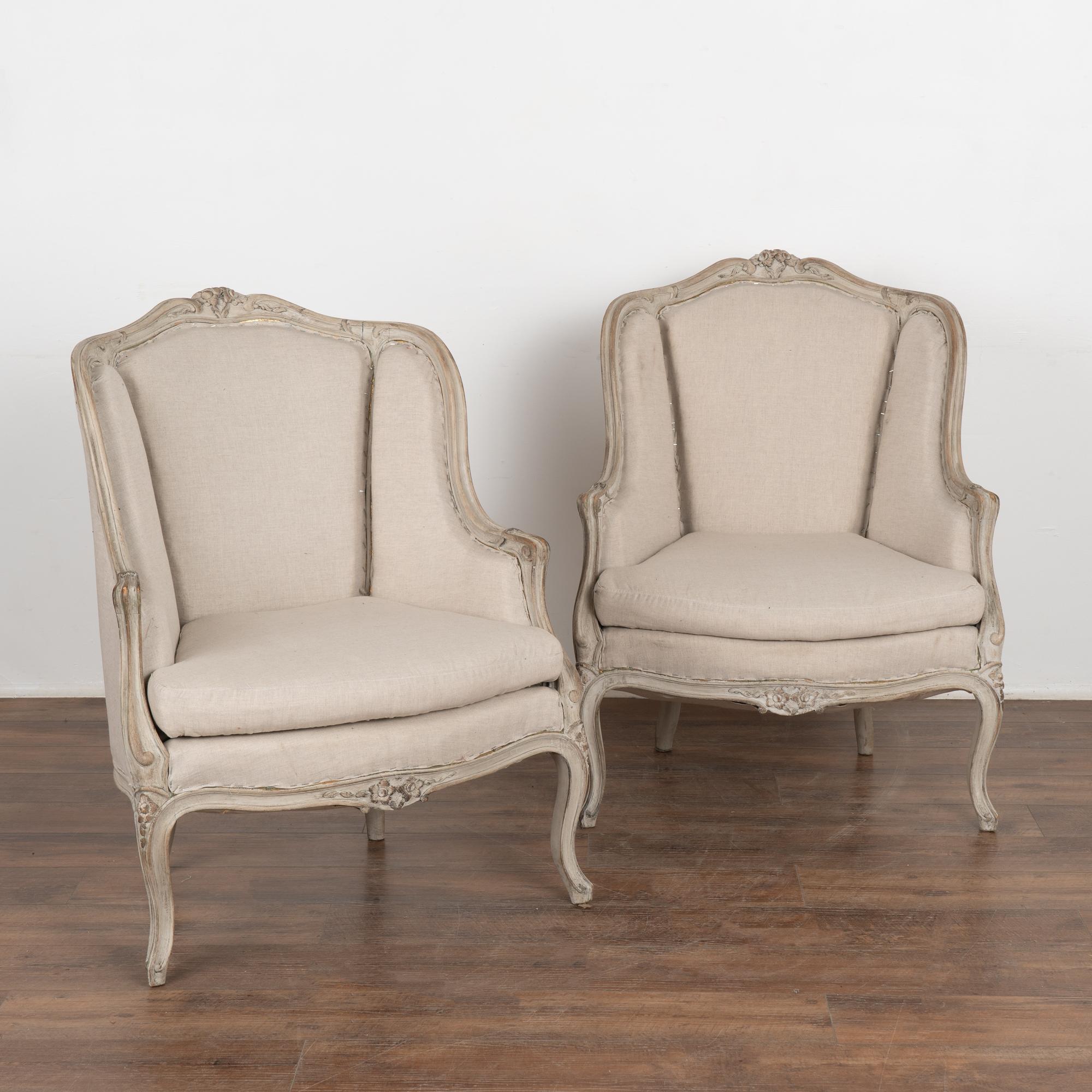 Pair, attractive Swedish country Gustavian style gray painted arm chairs with high backs.
Carved floral details along top and skirt, graceful curved arms, resting on cabriolet legs which combine to create the romantic appeal of this pair. 
The gray