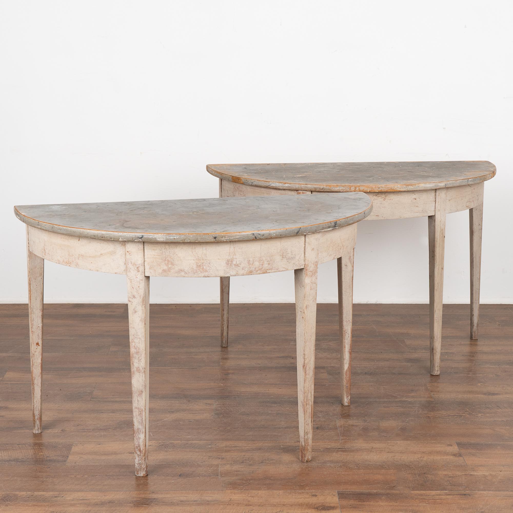 This pair of gray painted demi-lune tables with tapered legs still maintains the original painted finish with faux marble top which was a traditional Swedish style element of the era.
Note one of the tops shows much more distress with wear all the