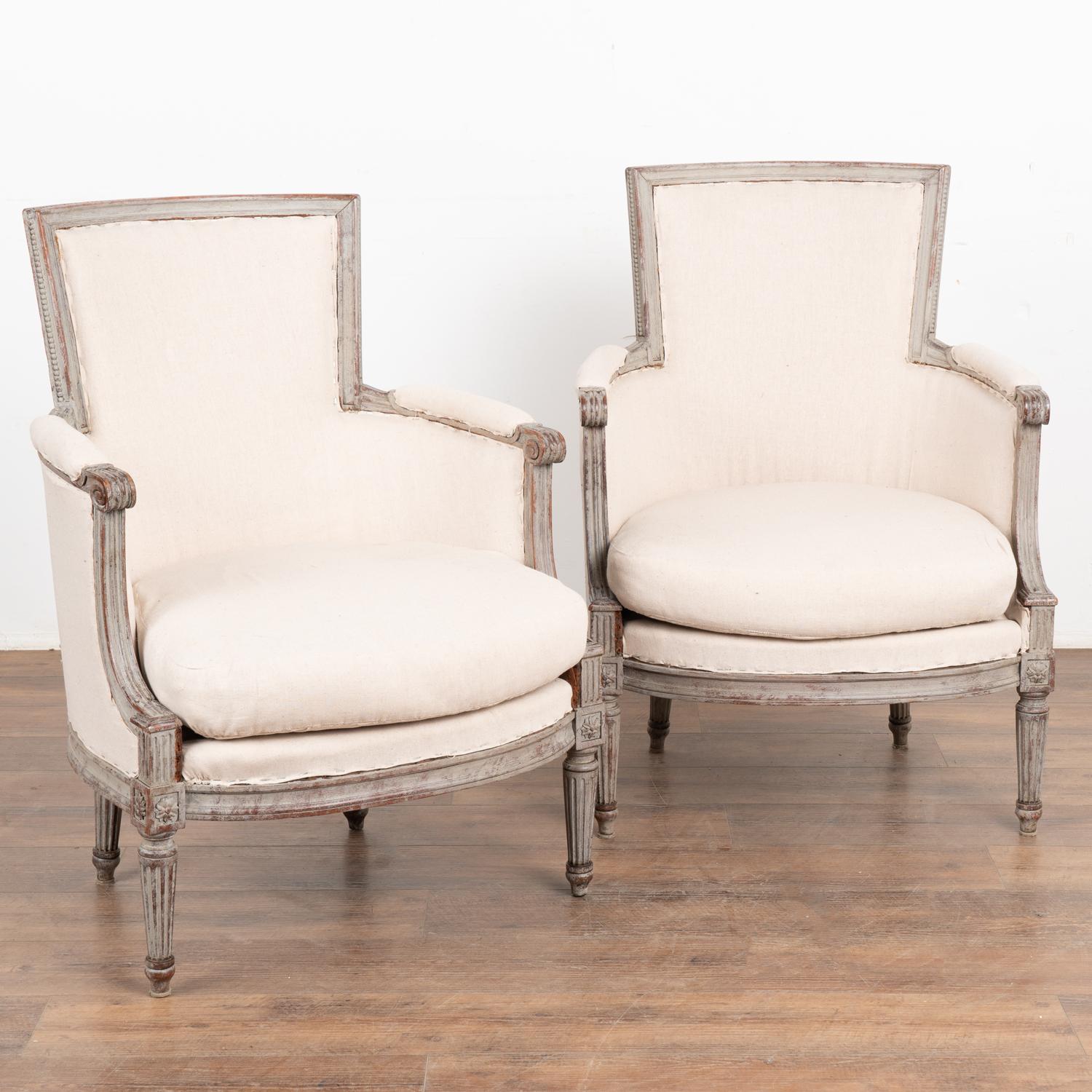 This pair of Swedish Gustavian style armchairs have a gently curved back, turned fluted legs and decorative carving embellishments which all add to the graceful appeal of each.
The newer professionally applied antique gray layered painted finish has
