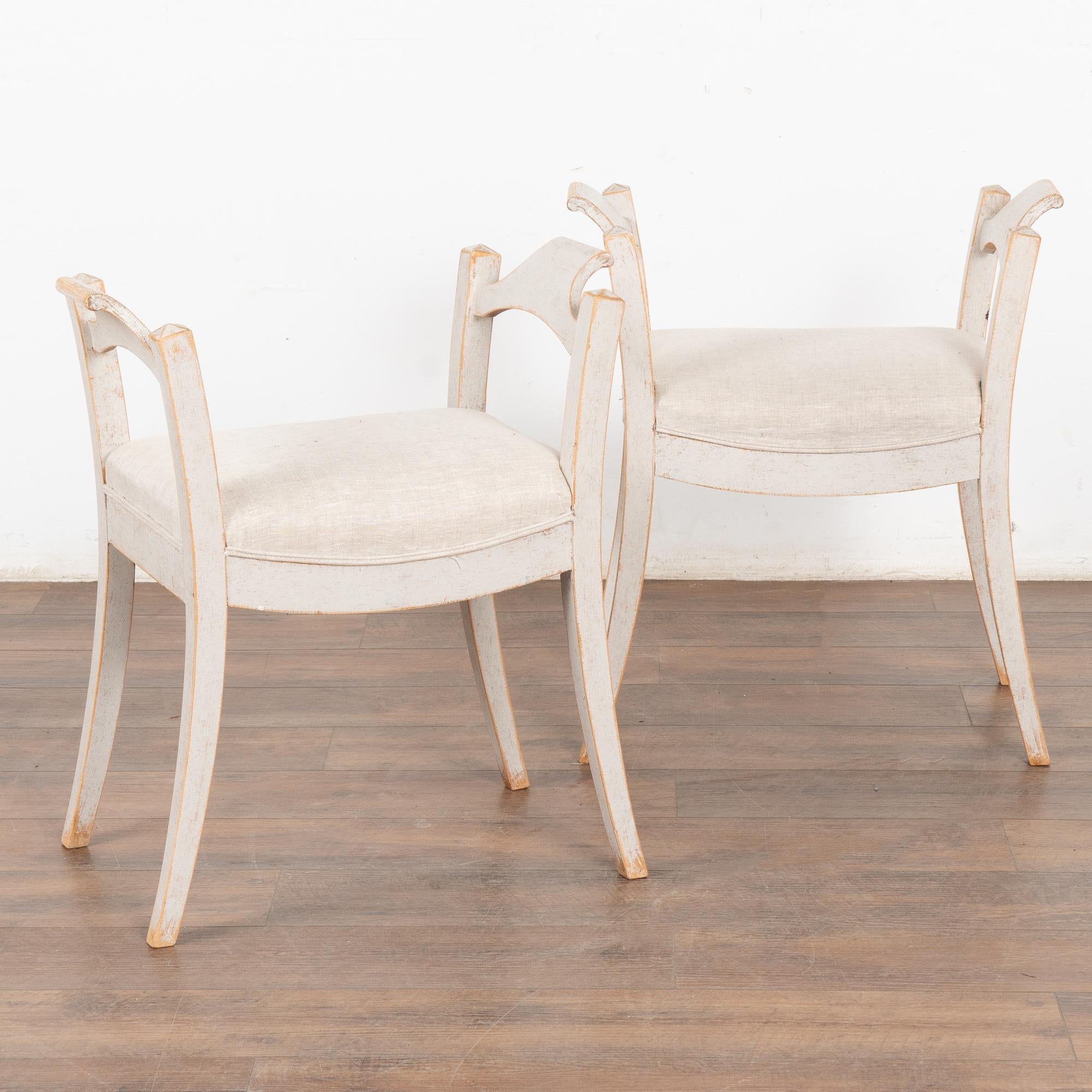 This lovely pair of Swedish stools or tabourets have gently curved, splayed legs which add an elegant touch to the pair.
The soft patina of the later paint adds to their charm. Upholstered in light colored linen.
This pair is restored, solid, stable