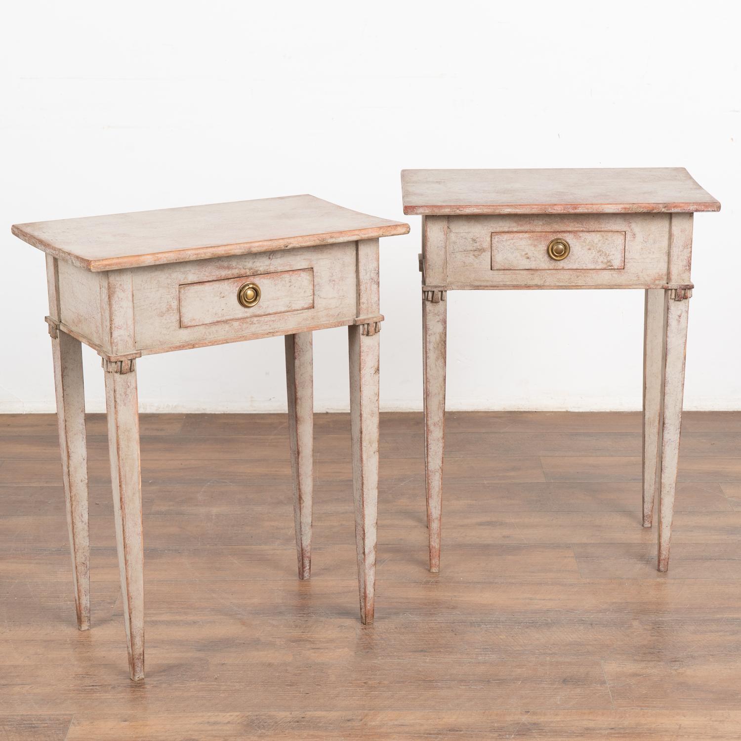 Pair, Swedish Gustavian style side tables with single petite drawer resting on graceful long tapered legs.
Restored, later professionally painted in layered/mottled shades of soft gray with plum and white undertones all lightly distressed to fit the