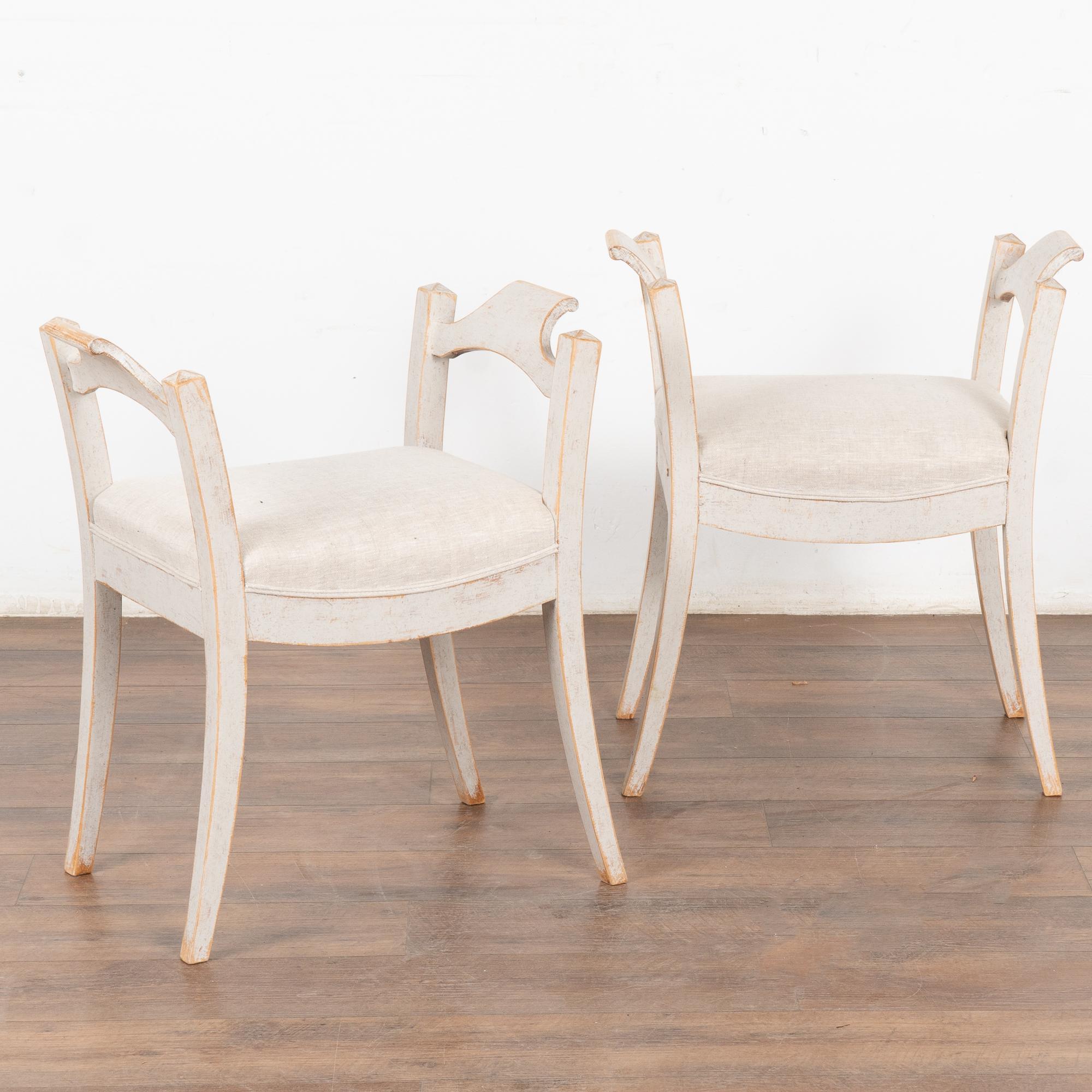 This lovely pair of Swedish stools or tabourets have gently curved, splayed legs which add an elegant touch to the pair.
The soft patina of the later paint adds to their charm. Upholstered in light colored linen.
This pair is restored, solid, stable
