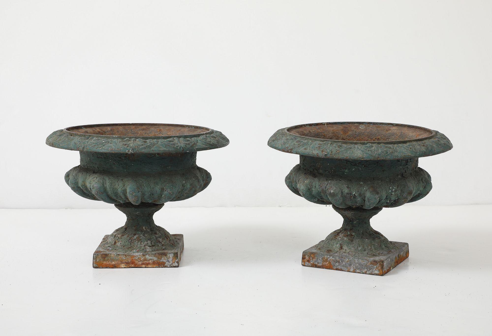 Queste urne in ghisa dipinte di verde sono un bellissimo esempio di design francese. Queste urne dei primi del Novecento hanno una qualità senza tempo che le rende un'aggiunta perfetta a qualsiasi giardino o spazio esterno. Le urne sono realizzate