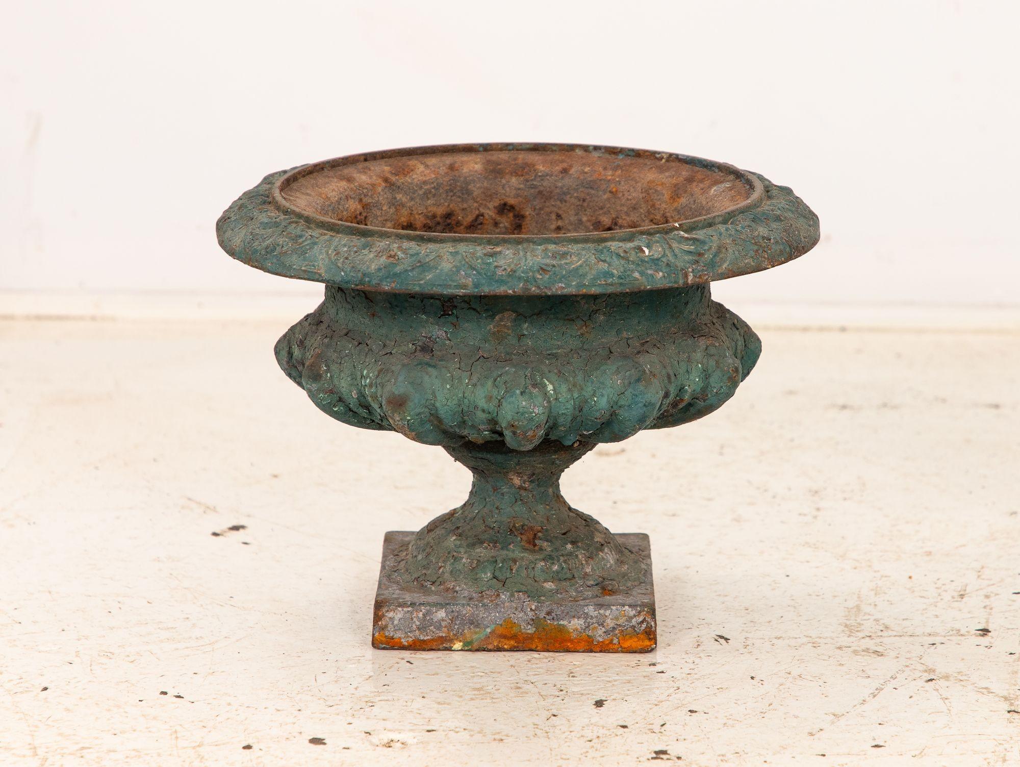 Queste urne in ghisa dipinte di verde sono un bellissimo esempio di design francese. Queste urne dei primi del Novecento hanno una qualità senza tempo che le rende un'aggiunta perfetta a qualsiasi giardino o spazio esterno. Le urne sono realizzate