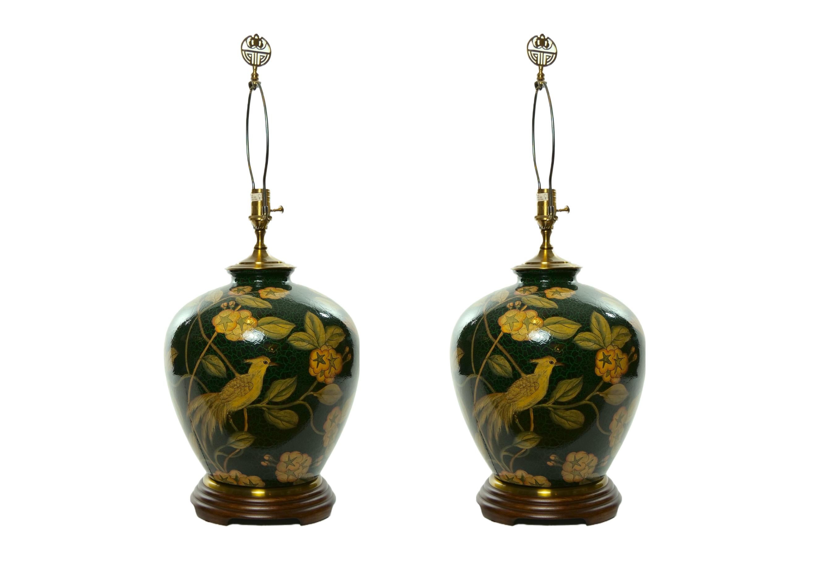 Pair glazed porcelain with wood base decorative ginger jar vases mounted as table lamps with exterior hand painted flower blossom and birds decoration design details. Each lamp is in good working condition. Minor wear consistent with age / use. No