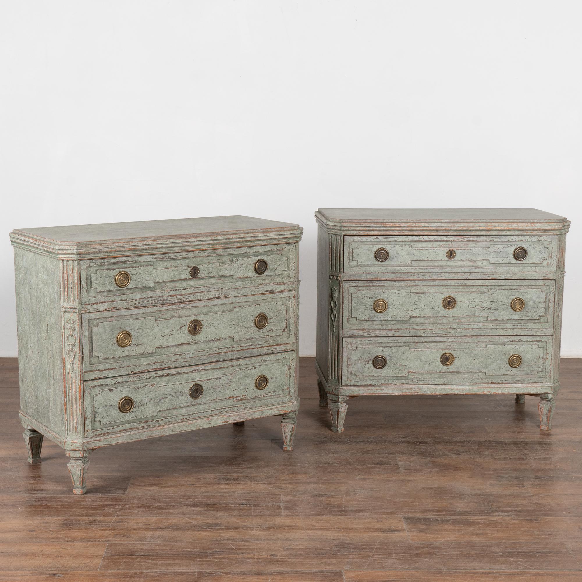 A pair of decorative Gustavian pine chest of drawers with canted fluted side posts with upper carved diamond medallion, raised carved panels along the three drawers, all setting on four tapered fluted feet.
The newer, professionally applied seafoam
