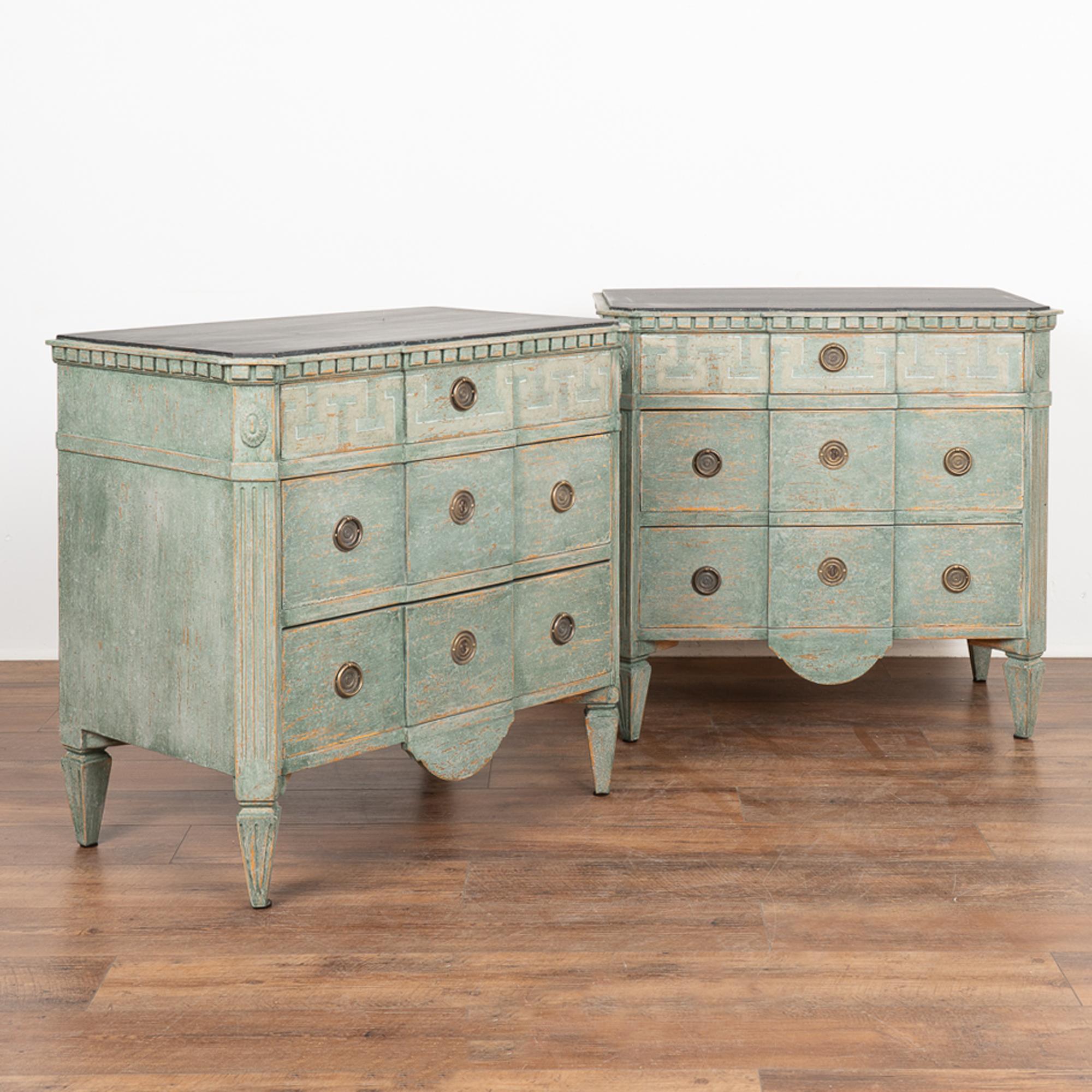 A pair of decorative pine Gustavian chest of three drawers with traditional dentil molding; upper drawer decorated with lightly painted Greek key motif. 
Restored, later professionally painted in layered shades of teal blues and greens with