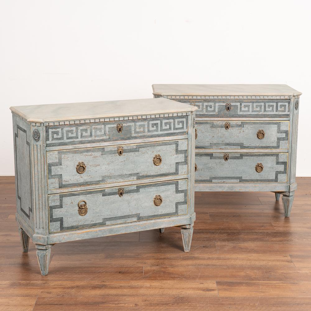 A pair of decorative Gustavian style chest of drawers painted in shades of blue, fitting their Swedish origin.
Traditional faux marble painted top and carved dentil moldings.
Three drawers, upper drawer decorated with painted Greek key