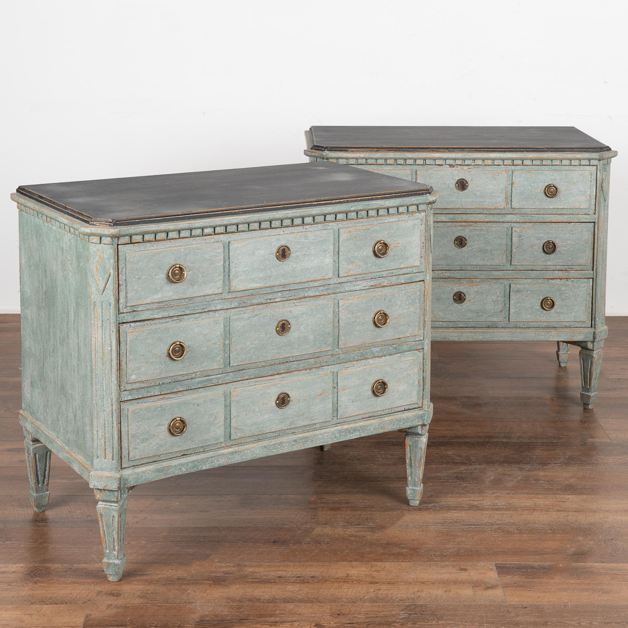 A pair of decorative Gustavian pine chest of drawers with canted fluted side posts with upper carved diamond medallion and dentil molding. All resting on four tapered fluted feet.
The newer, professionally applied layered blue/seafoam (with soft