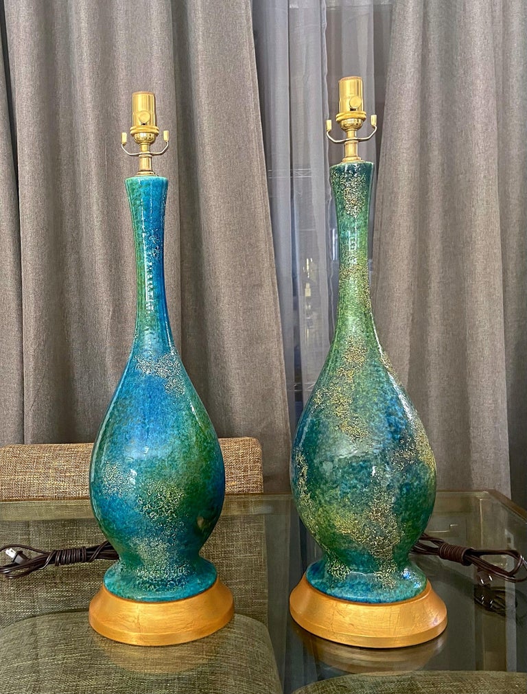 Pair of etruscan lava glaze finish ceramic table lamps by Royal Haeger, in vibrant blue and turquoise green. Lamps rest on decorative gilt metal bases. Newly rewired with new 3-way sockets, cords and brass fittings. Midcentury modern at its best.