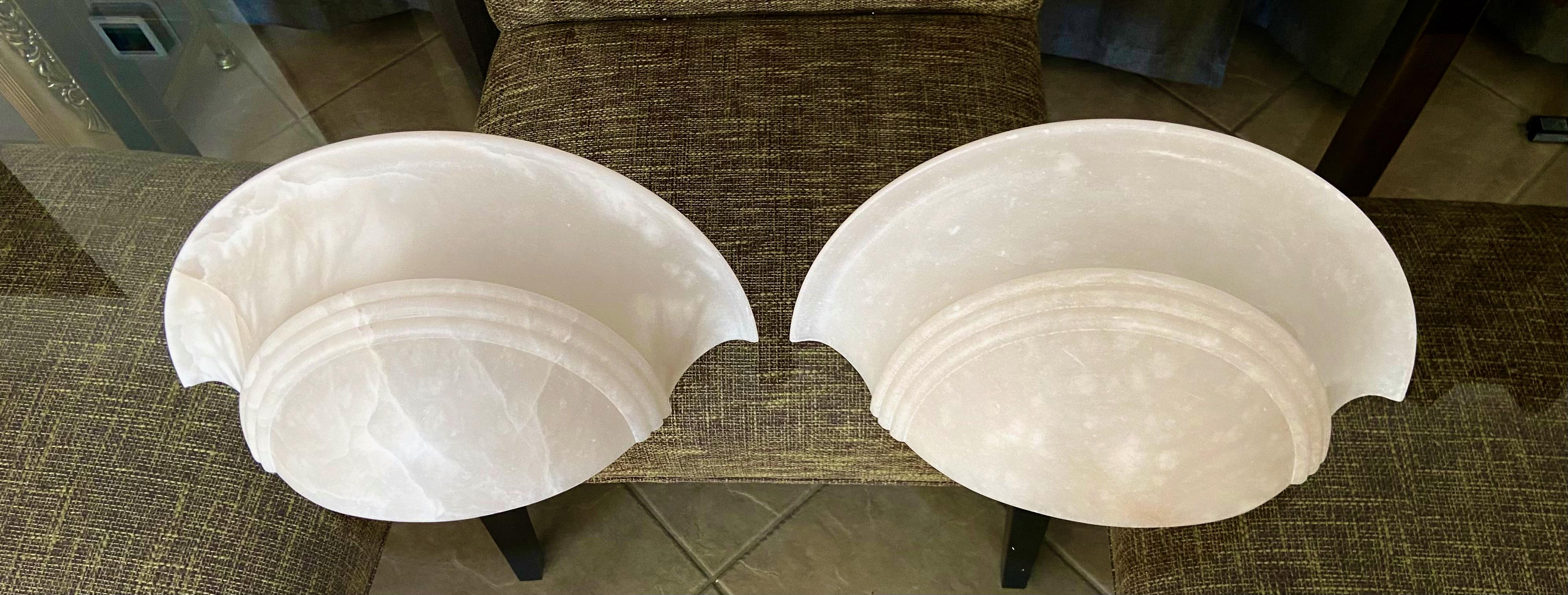 Pair of alabaster half moon or quarter shape wall sconces. Uses regular a base bulb, newly wired for US. 