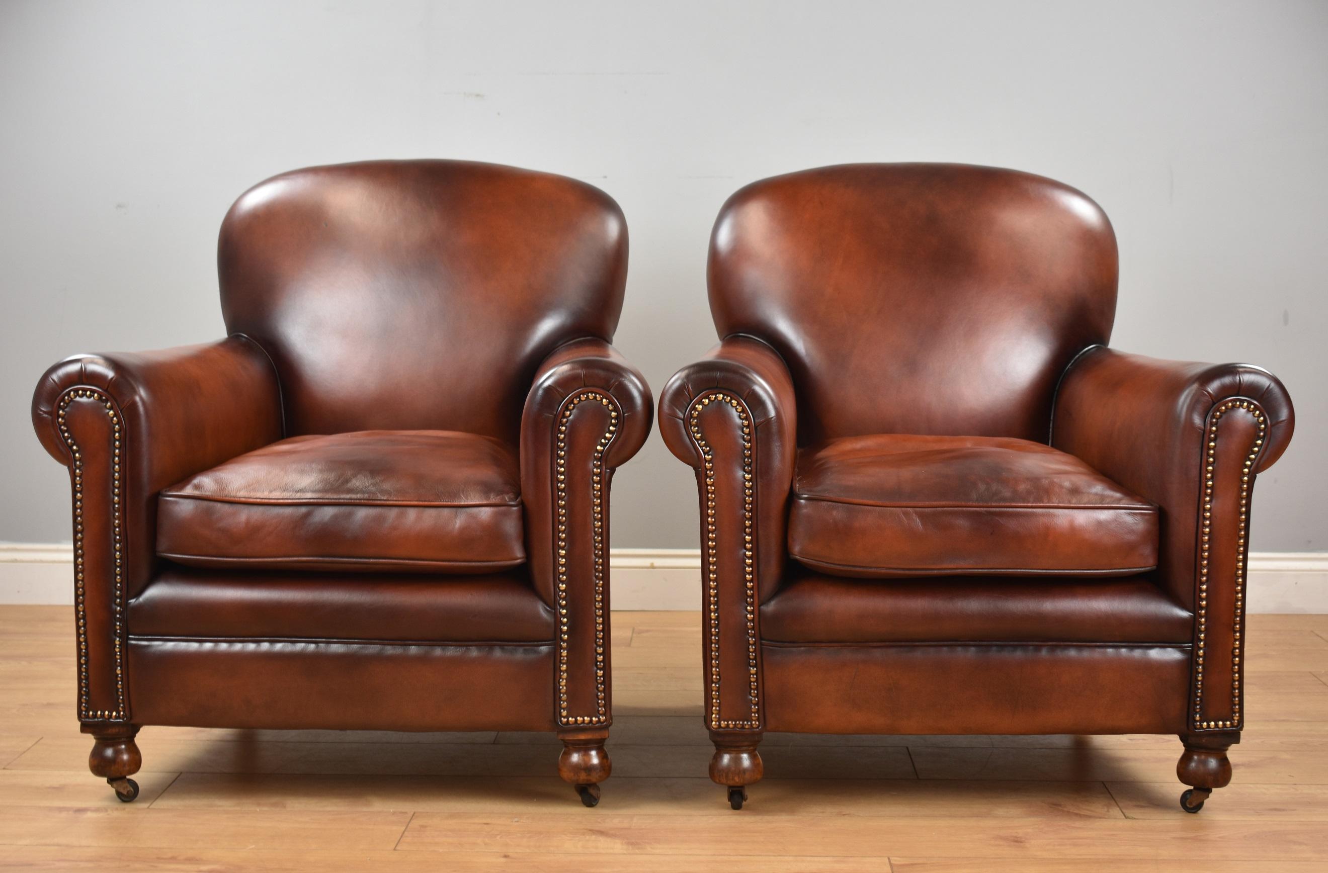 Superb pair of hand dyed honey brown leather armchairs with close studding to the arms and back standing on elegant feet with castors.