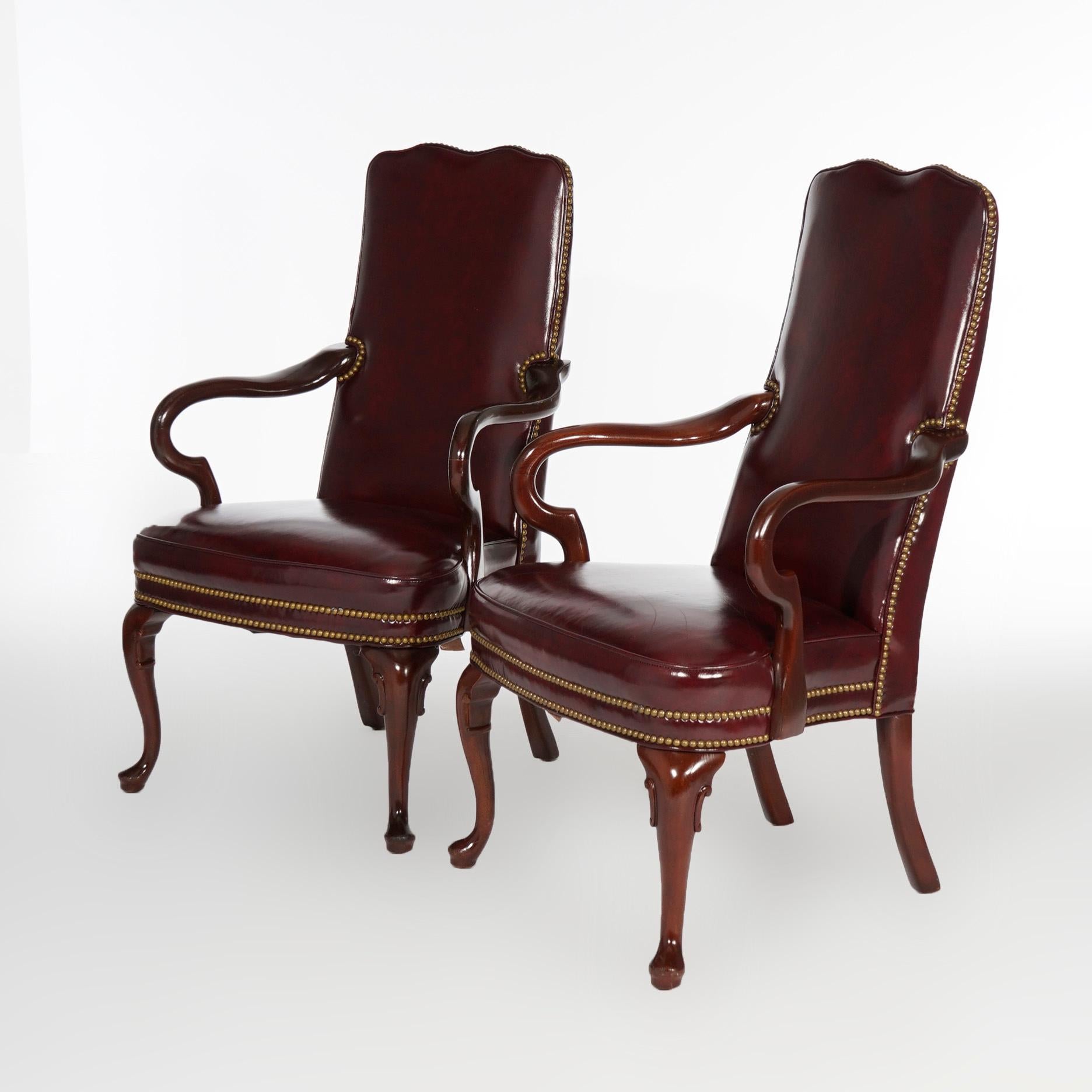 A pair of Queen Anne style high back armchairs by Hancock and Moore offer leather covered shaped back and seat on mahogany frame having scroll arms and raised on cabriole legs, maker label as photographed, 20th century

Measures- 43''H x 27.5''W x